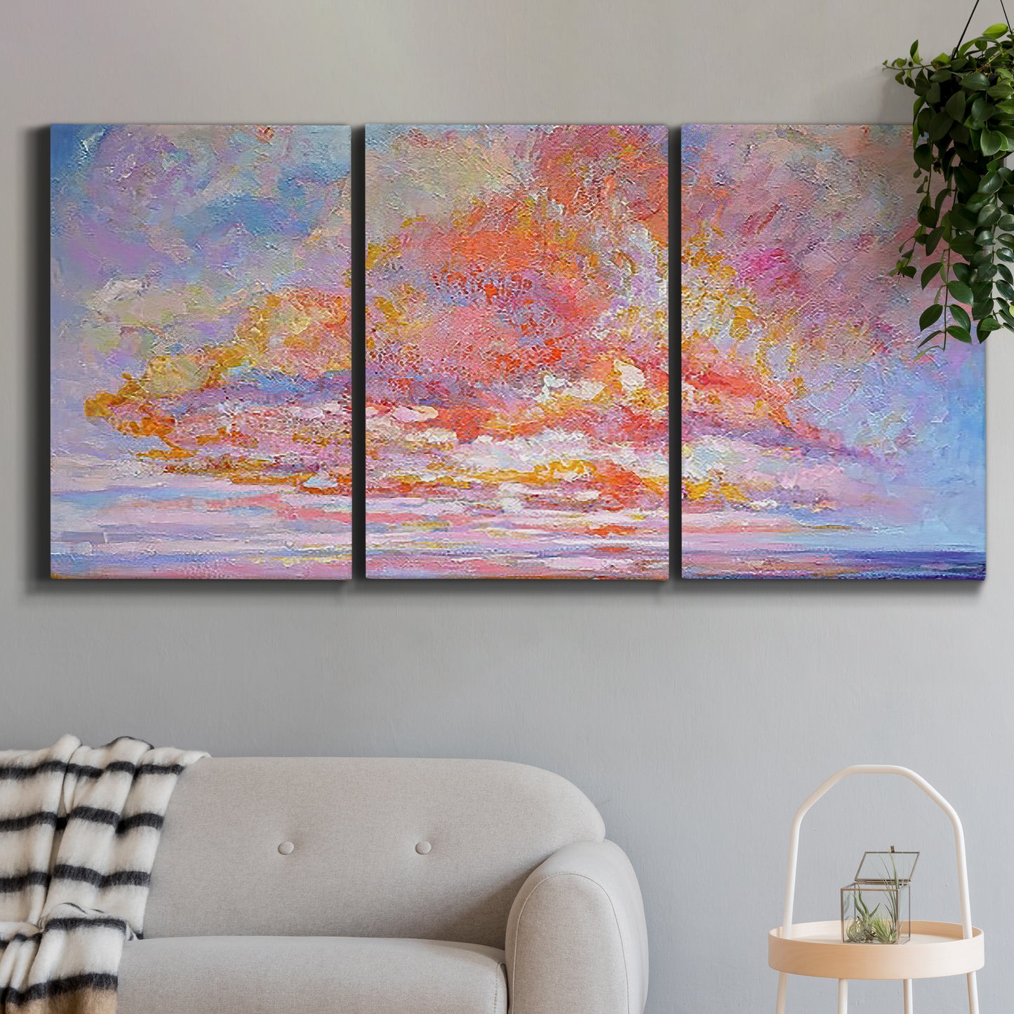 Three-panel canvas wall art featuring peaceful tropical inspired landscape, displayed in a modern living room above a sofa.