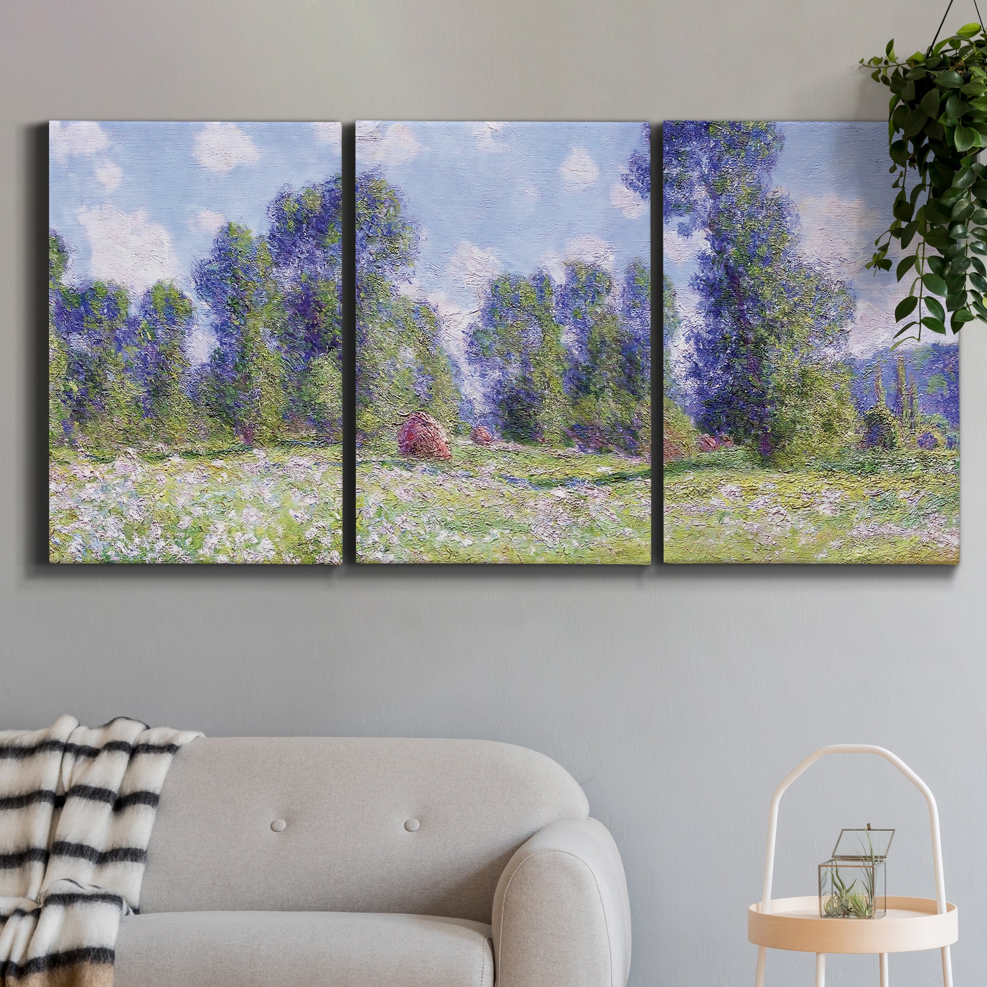 Three-panel canvas wall art featuring poppy field near garden village, displayed in a modern living room above a sofa.