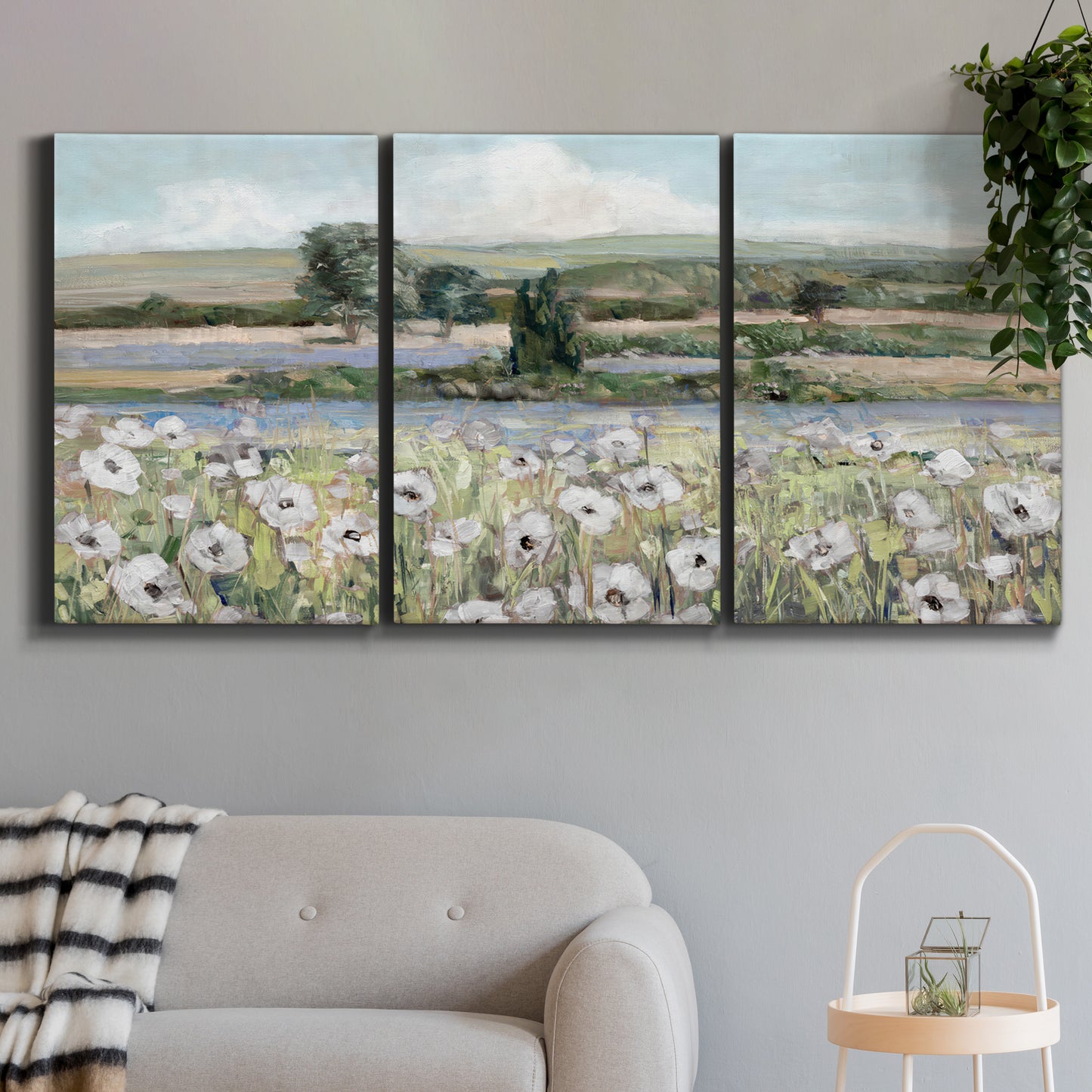 Three-panel canvas wall art featuring vintage poppy filled valley, displayed in a modern living room above a sofa.