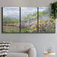 Three-panel canvas wall art featuring spring orchard in full bloom, displayed in a modern living room above a sofa.