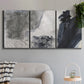 Three-panel canvas wall art featuring dark abstract atmospheric landscape, displayed in a modern living room above a sofa.