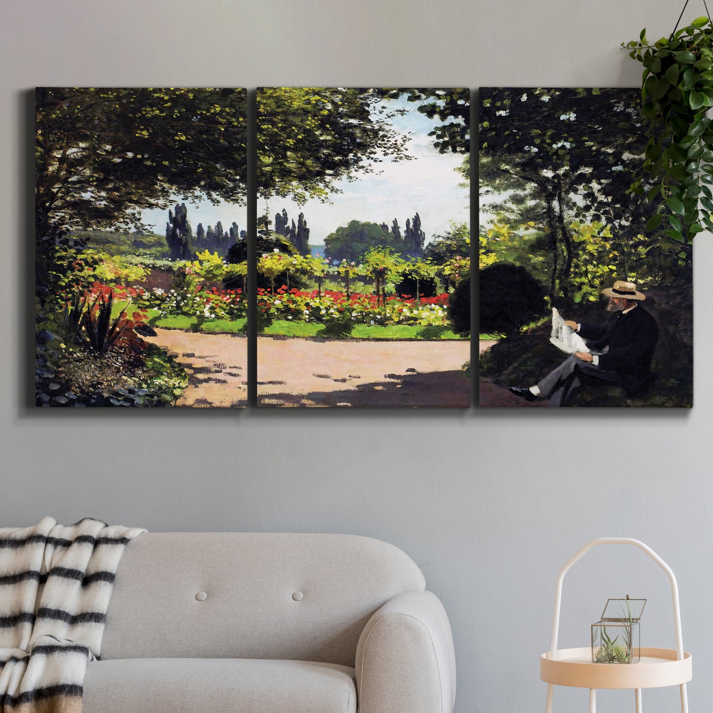 Three-panel canvas wall art featuring coastal garden overlooking sea, displayed in a modern living room above a sofa.
