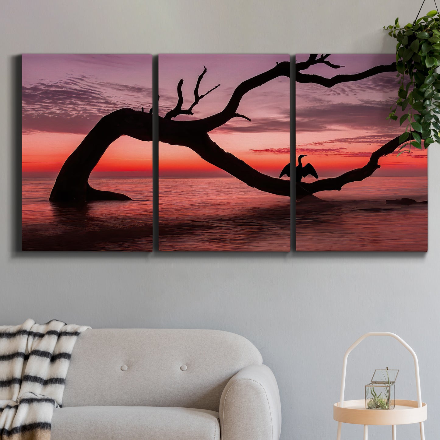 Three-panel canvas wall art featuring sunset beach photography, displayed in a modern living room above a sofa.