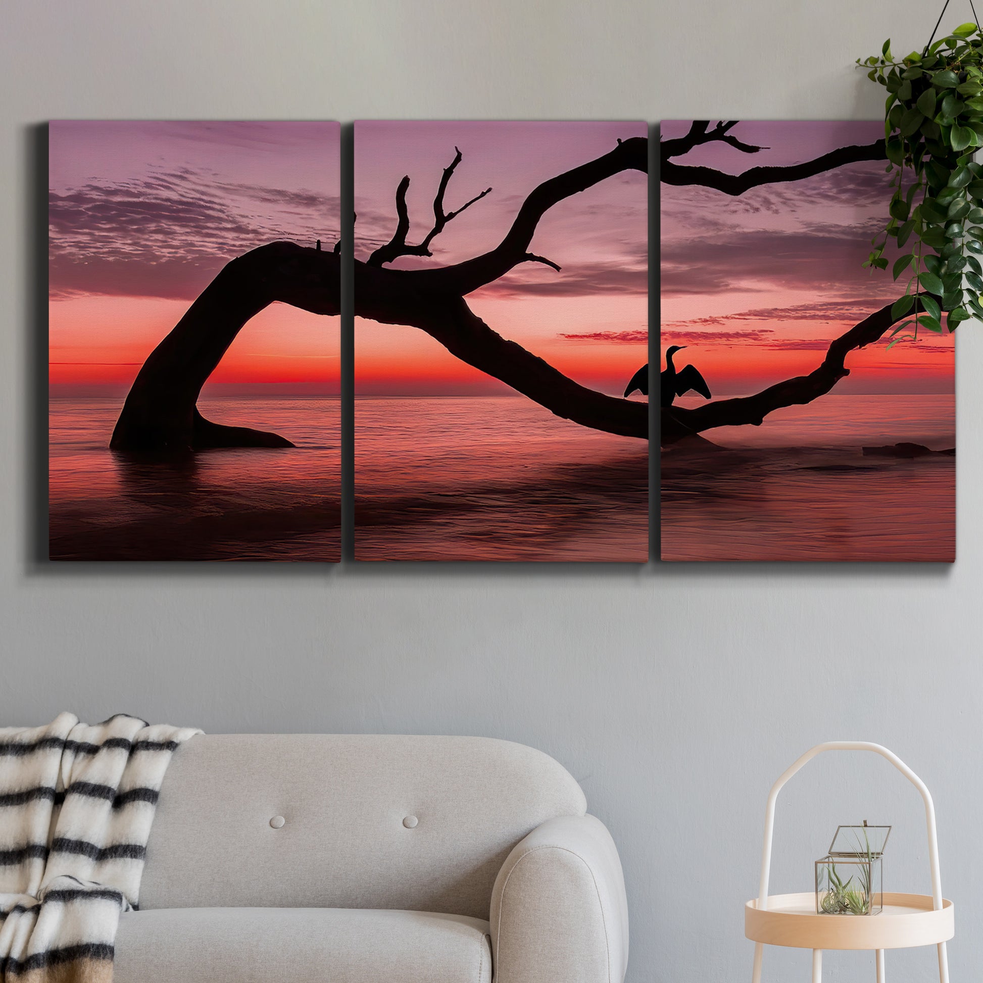 Three-panel canvas wall art featuring sunset beach photography, displayed in a modern living room above a sofa.