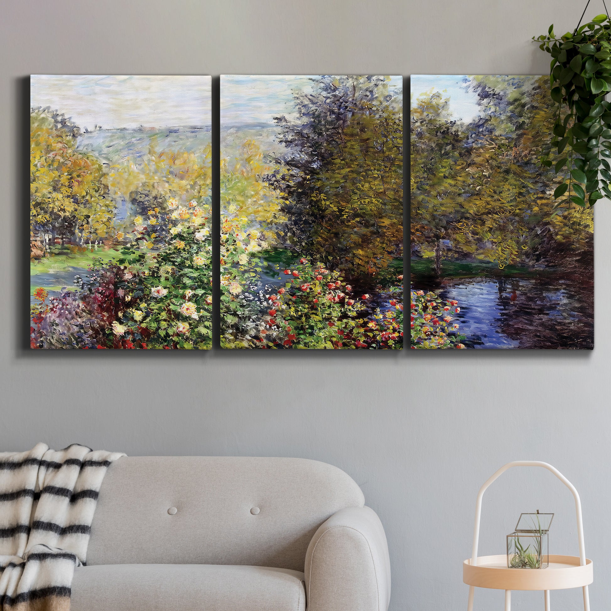 Three-panel canvas wall art featuring garden corner with flowering trees, displayed in a modern living room above a sofa.