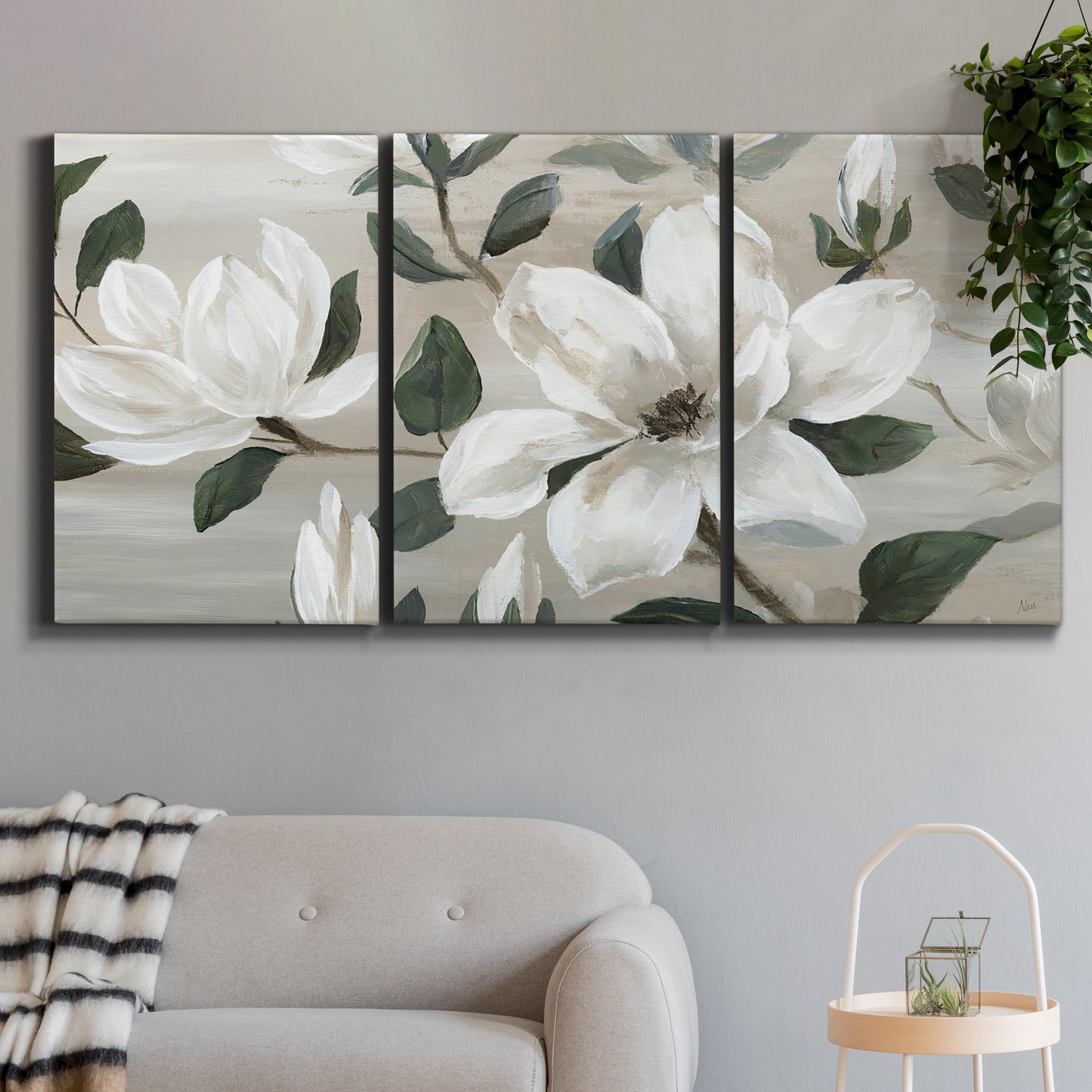 Three-panel canvas wall art featuring soft southern floral charm, displayed in a modern living room above a sofa.