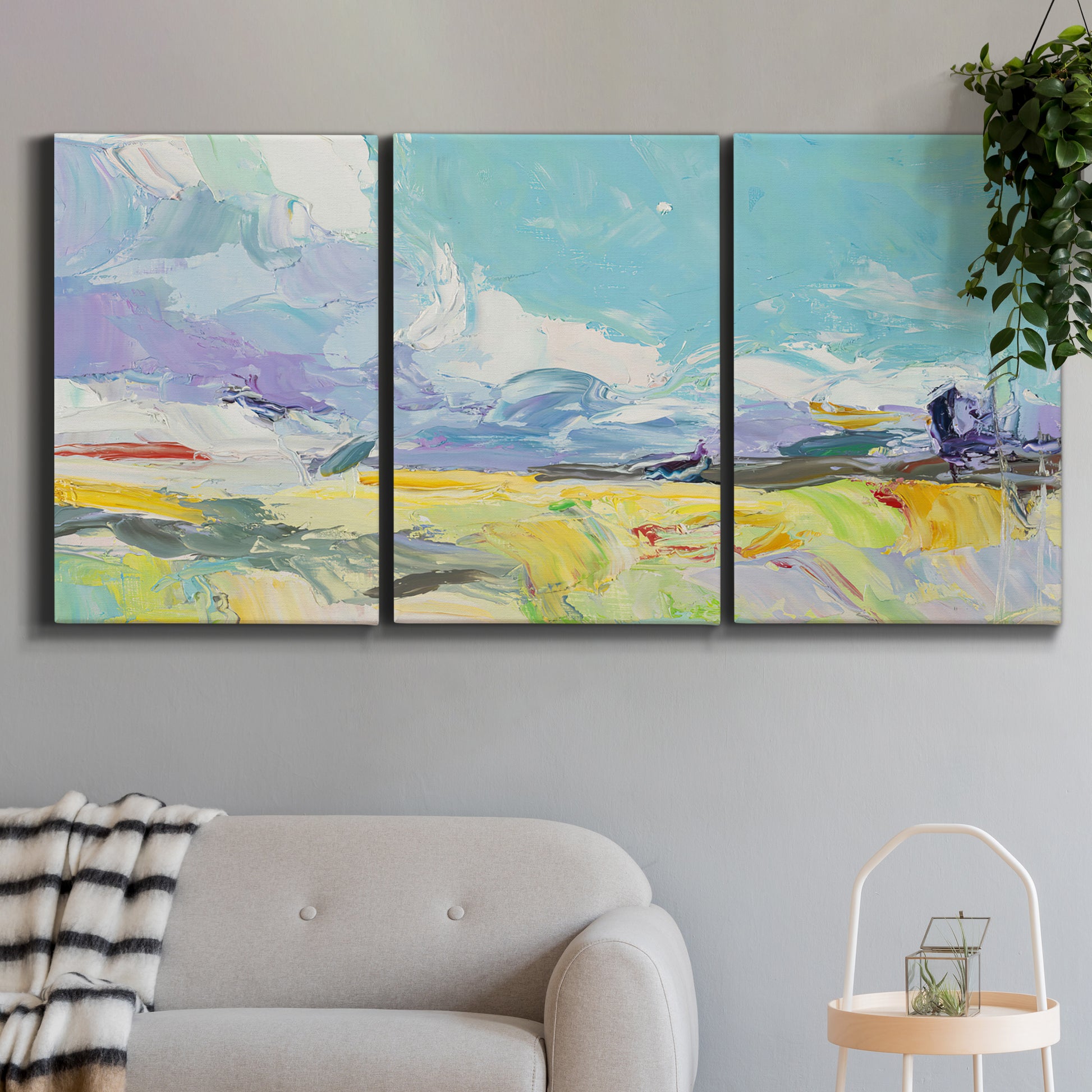 Three-panel canvas wall art featuring open landscape suggesting distant journey, displayed in a modern living room above a sofa.