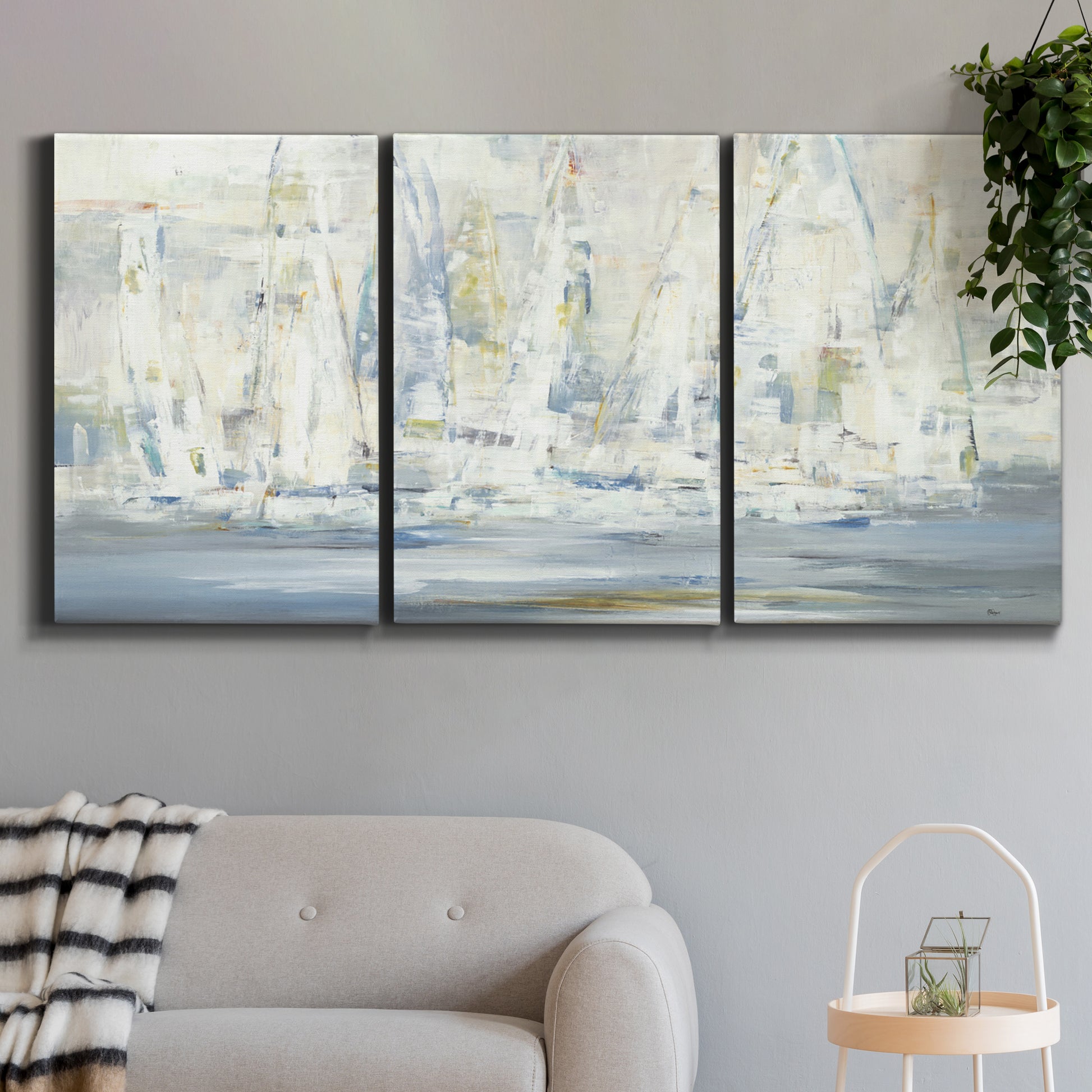 Three-panel canvas wall art featuring impressionist regatta scene with sailboats, displayed in a modern living room above a sofa.