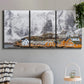 Three-panel canvas wall art featuring winter village street photography, displayed in a modern living room above a sofa.