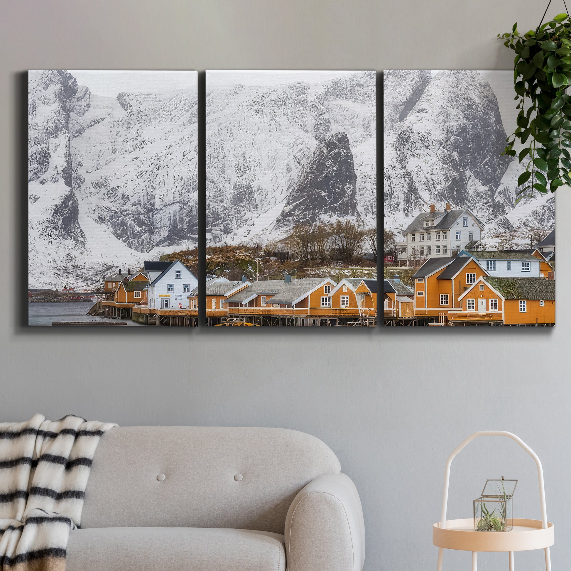 Three-panel canvas wall art featuring winter village street photography, displayed in a modern living room above a sofa.