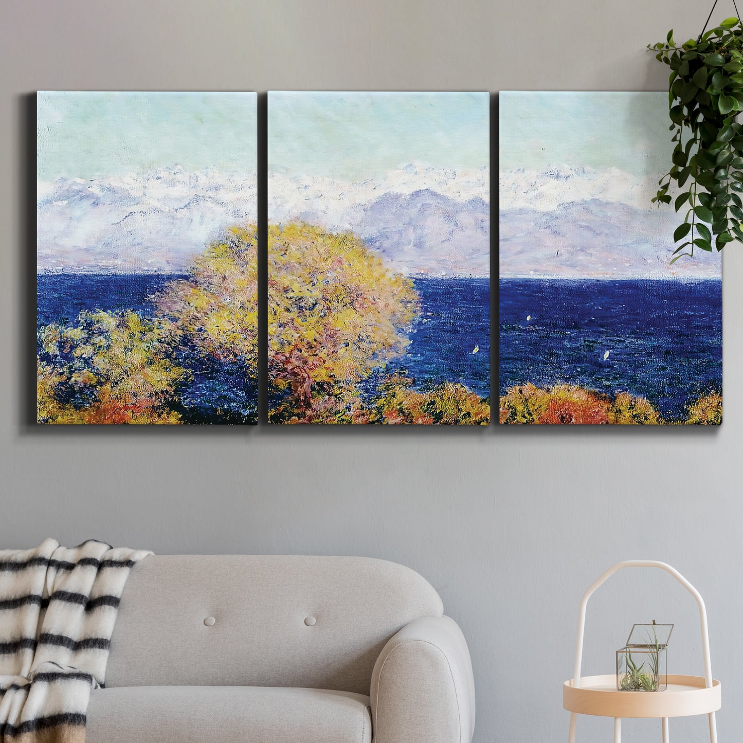 Three-panel canvas wall art featuring mediterranean coastline with headland, displayed in a modern living room above a sofa.