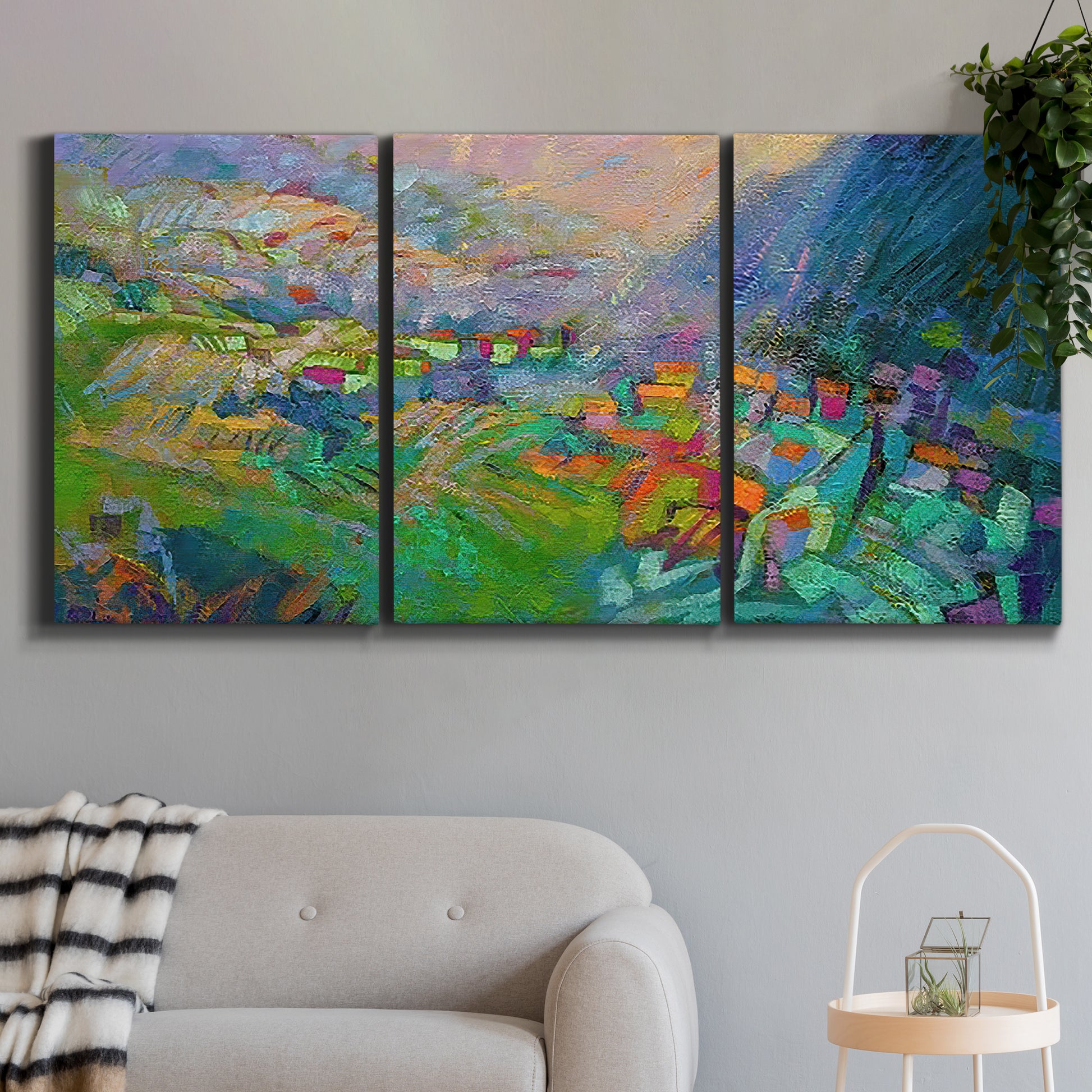 Three-panel canvas wall art featuring embracing landscape with warm tones, displayed in a modern living room above a sofa.