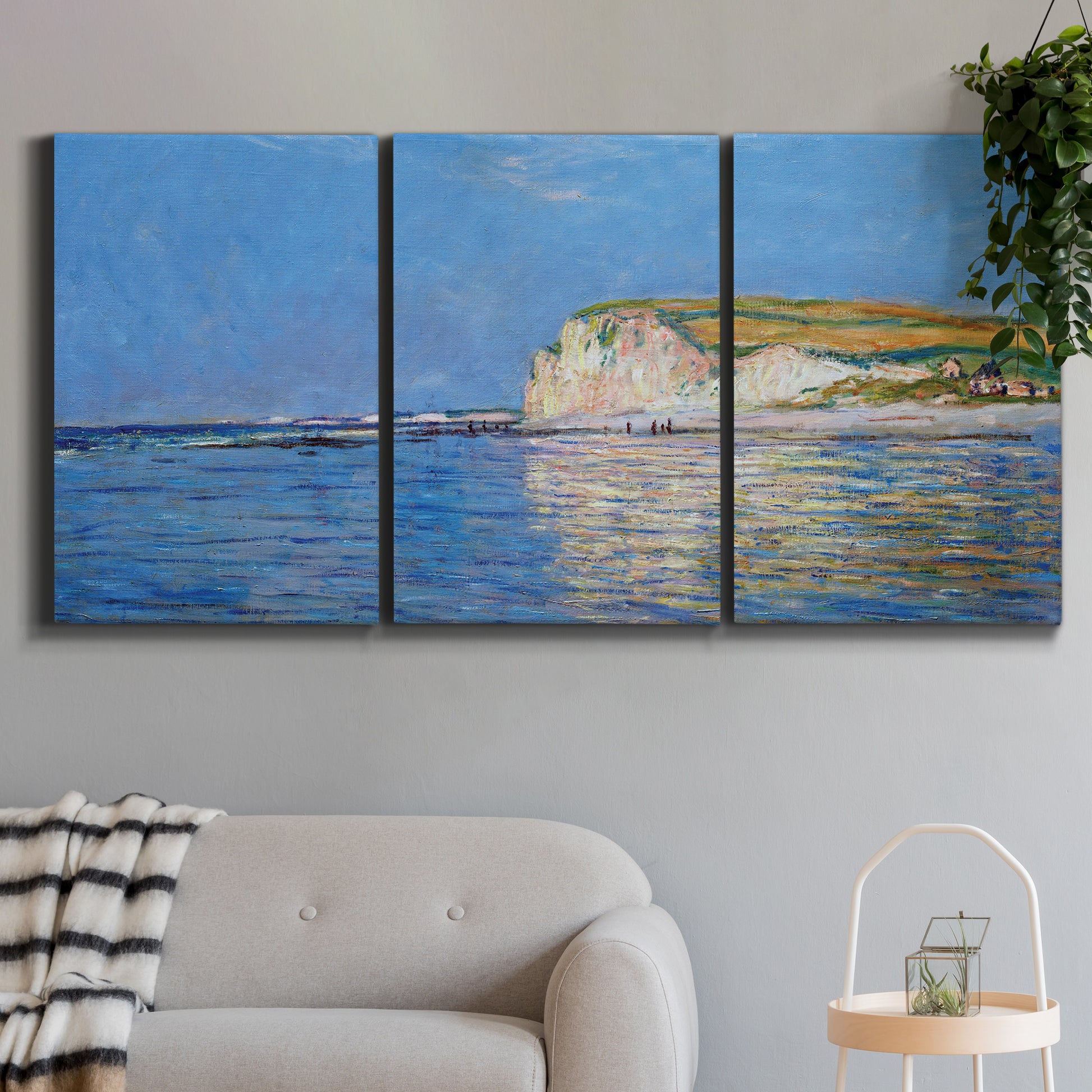 Three-panel canvas wall art featuring white cliffs rising above sea, displayed in a modern living room above a sofa.