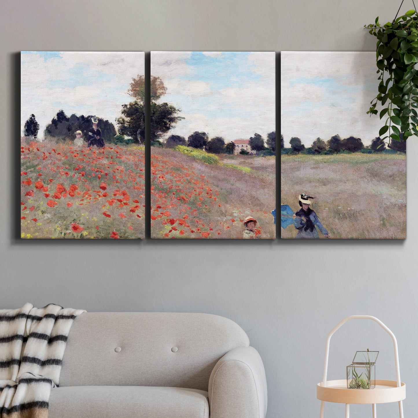 Three-panel canvas wall art featuring poppy field stretching across meadow, displayed in a modern living room above a sofa.