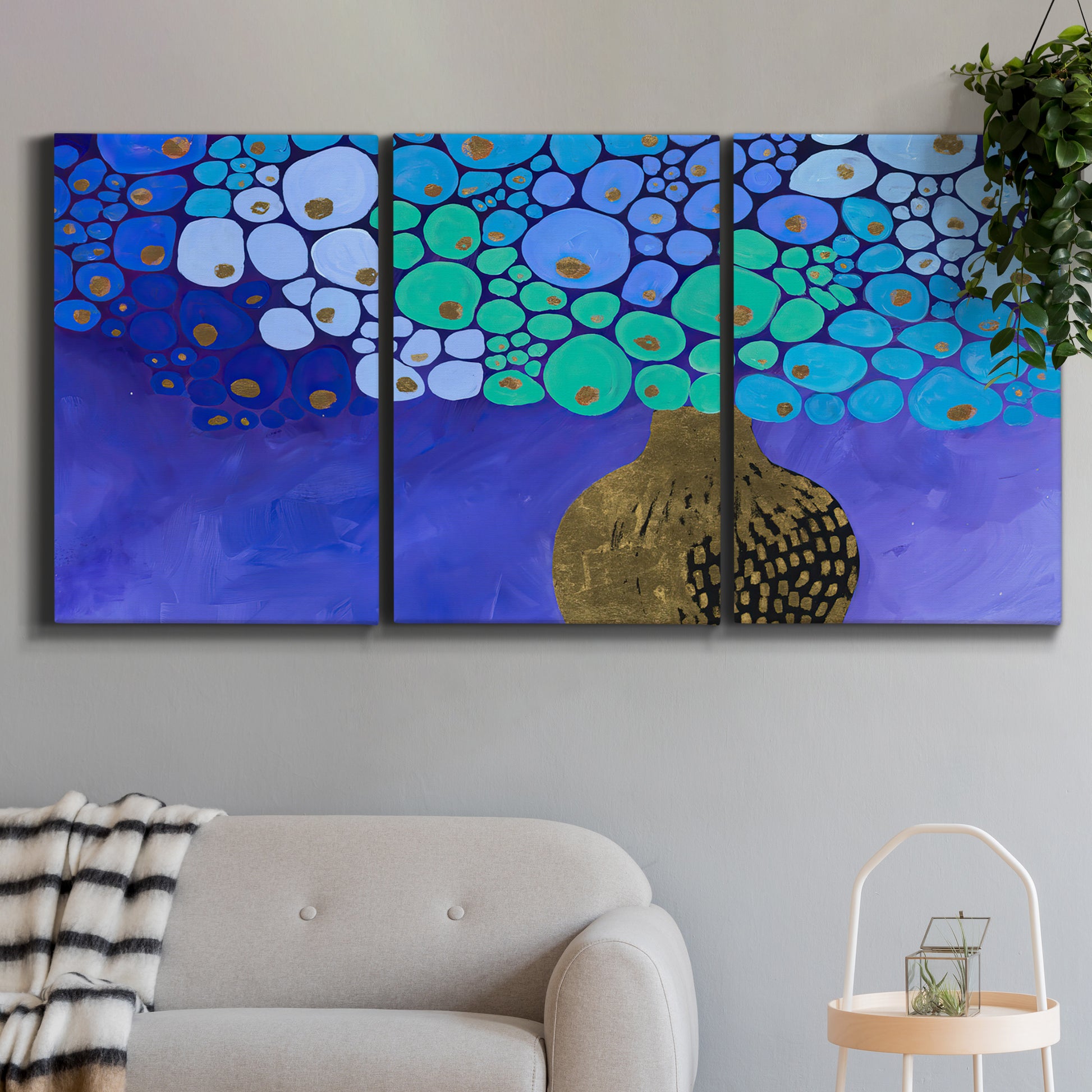 Three-panel canvas wall art featuring blue poppy floral abstraction, displayed in a modern living room above a sofa.