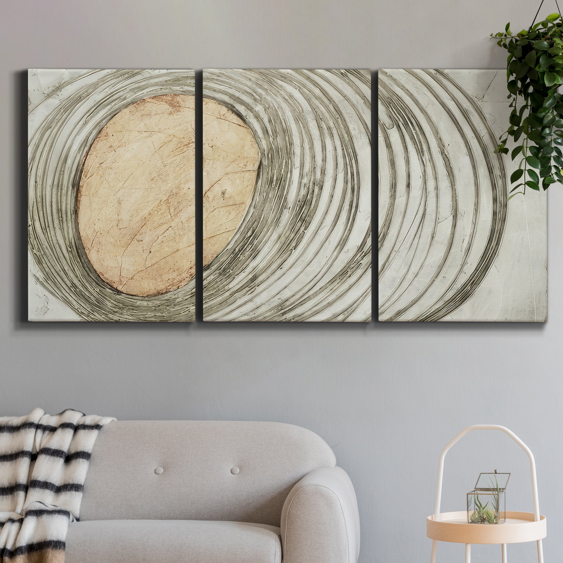 Three-panel canvas wall art featuring circular abstract energy forms, displayed in a modern living room above a sofa.