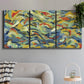 Three-panel canvas wall art featuring colorful abstract river like motion, displayed in a modern living room above a sofa.