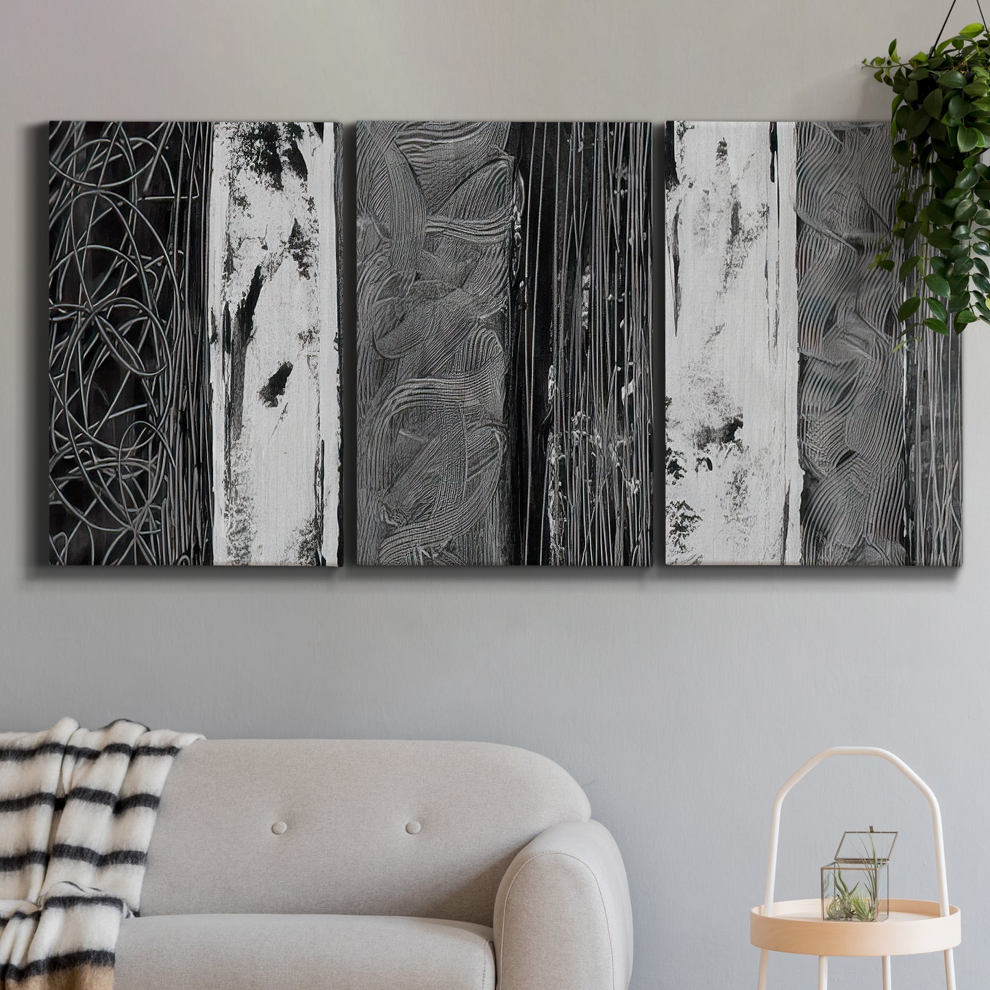 Three-panel canvas wall art featuring brushed metallic abstract textures, displayed in a modern living room above a sofa.