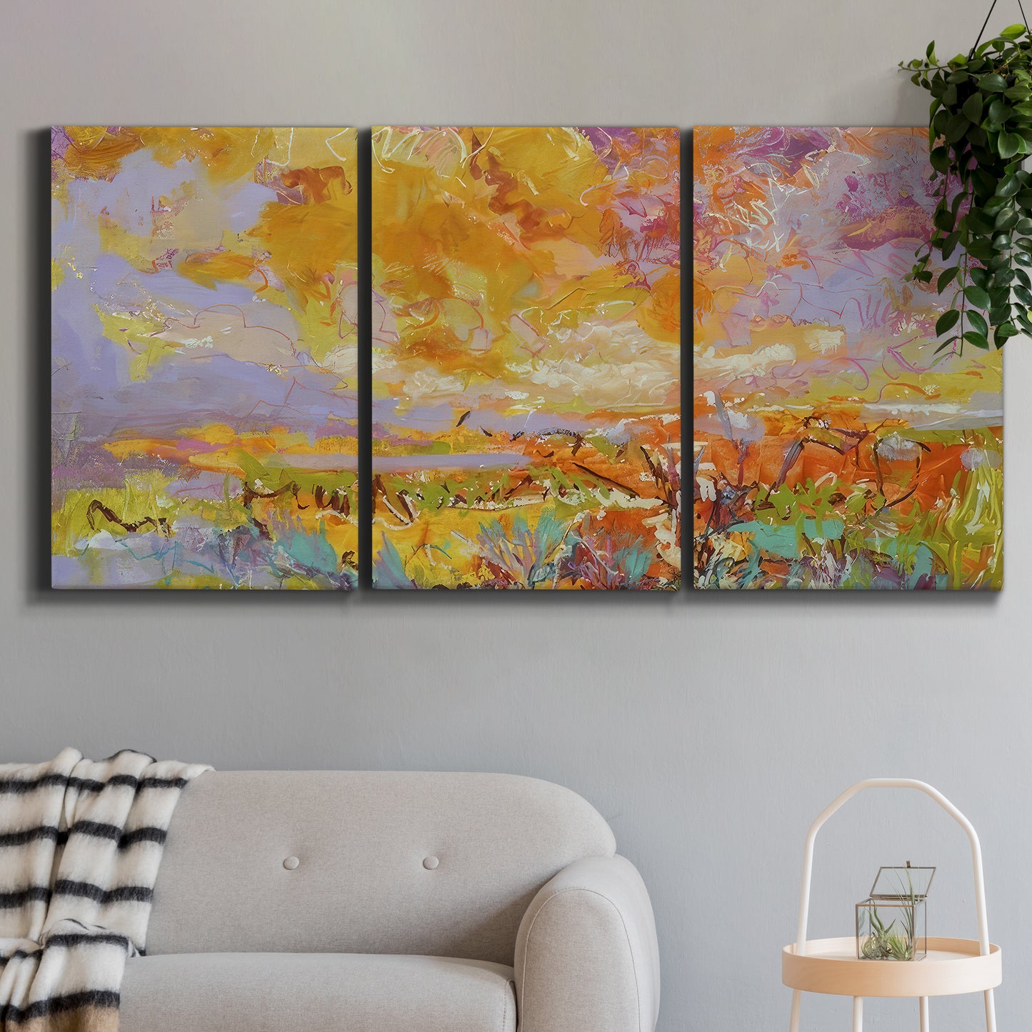 Three-panel canvas wall art featuring abstract meadow inspired color fields, displayed in a modern living room above a sofa.