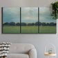 Three-panel canvas wall art featuring rolling green pastoral fields, displayed in a modern living room above a sofa.