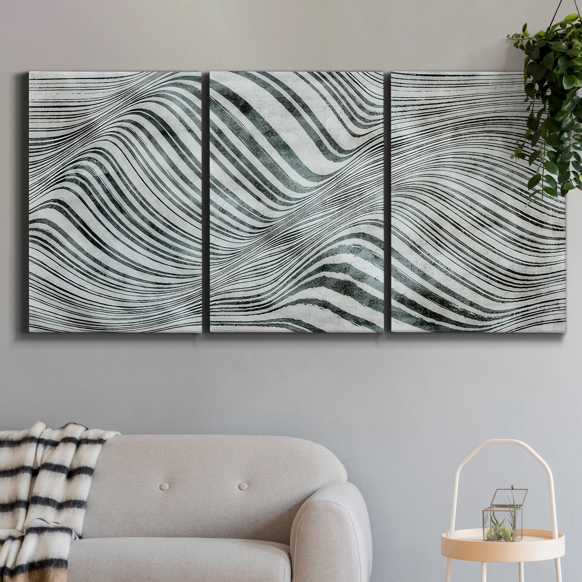 Three-panel canvas wall art featuring coastal shoreline with gentle surf, displayed in a modern living room above a sofa.