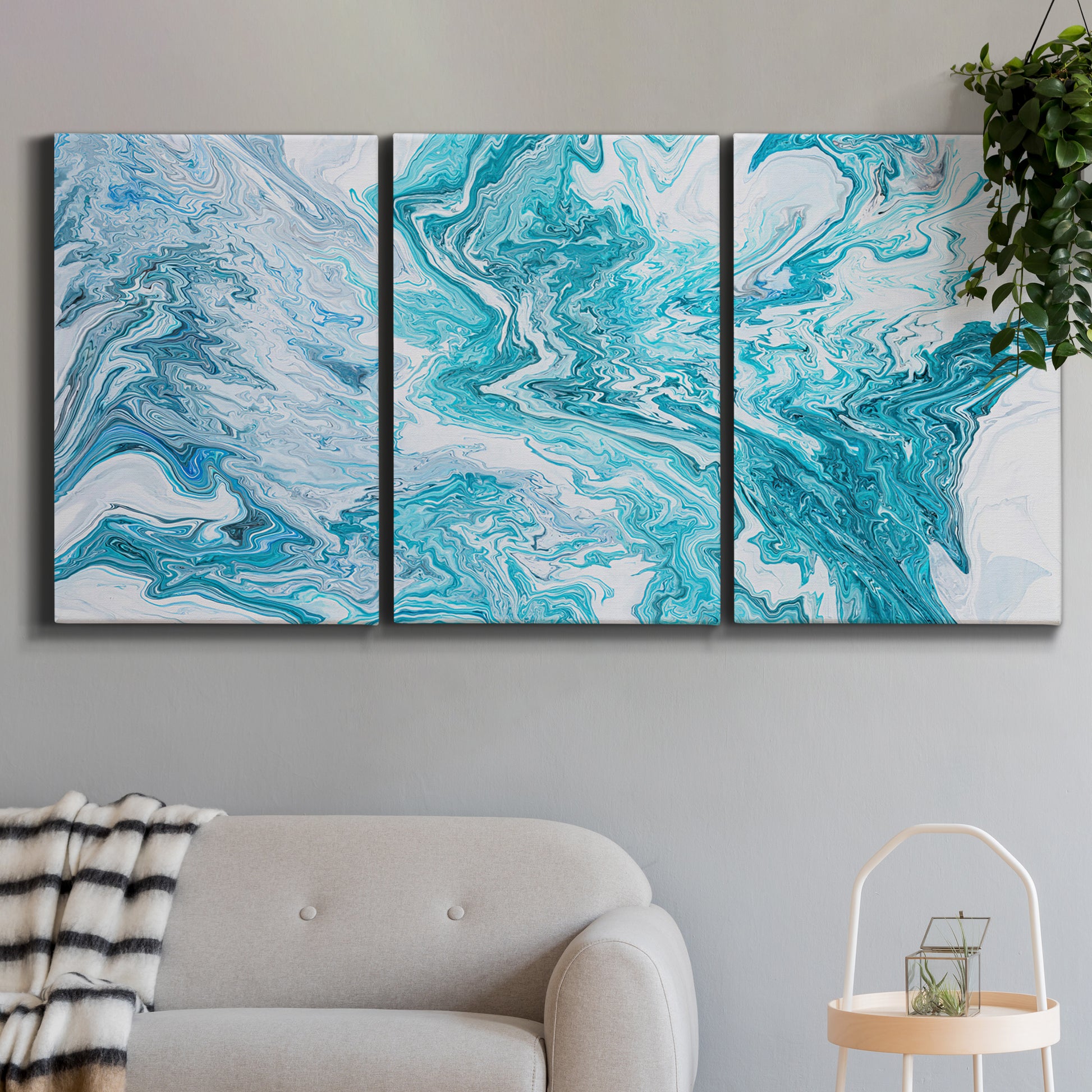 Three-panel canvas wall art featuring rocky coastal tide pool scene, displayed in a modern living room above a sofa.