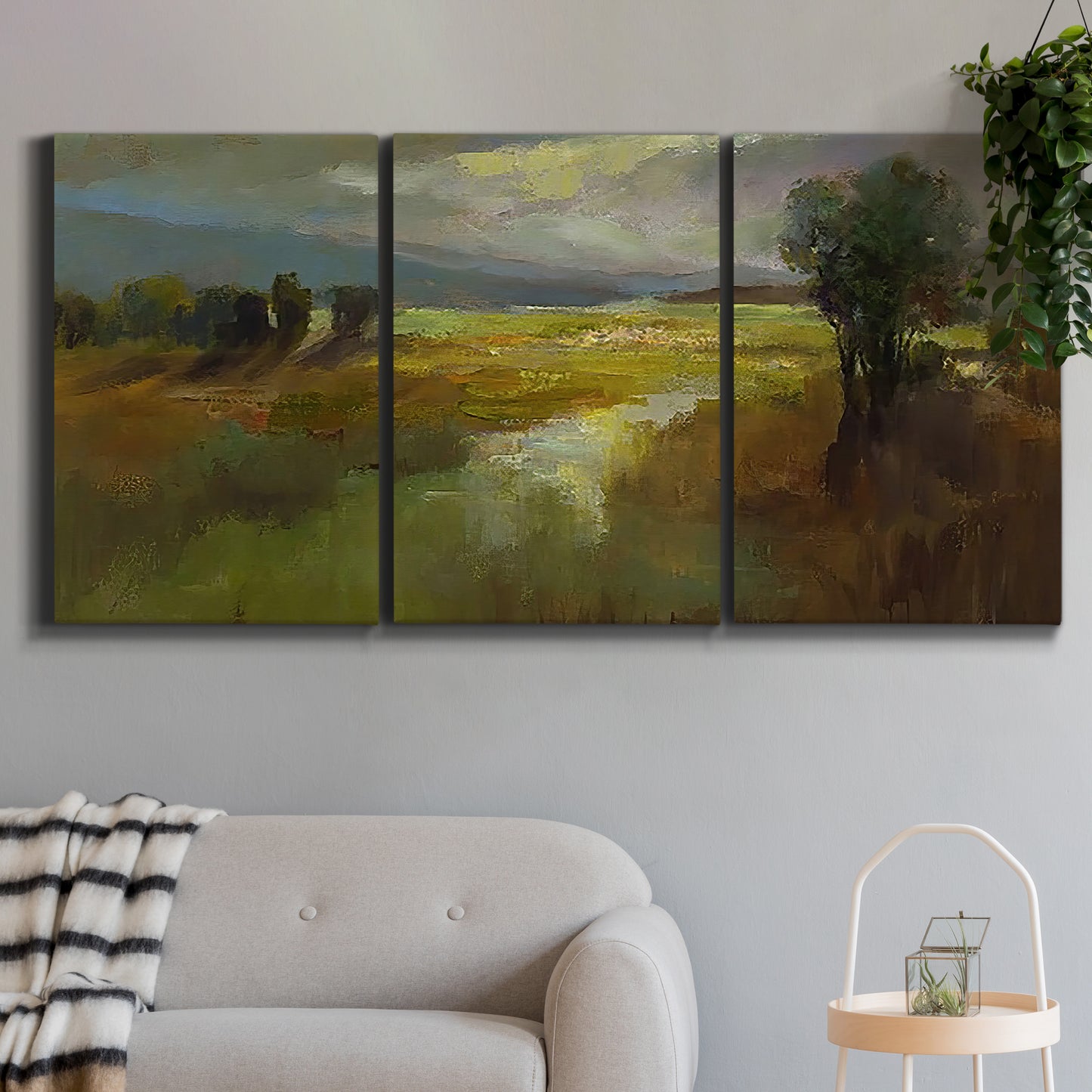 Three-panel canvas wall art featuring winding rural road through countryside, displayed in a modern living room above a sofa.