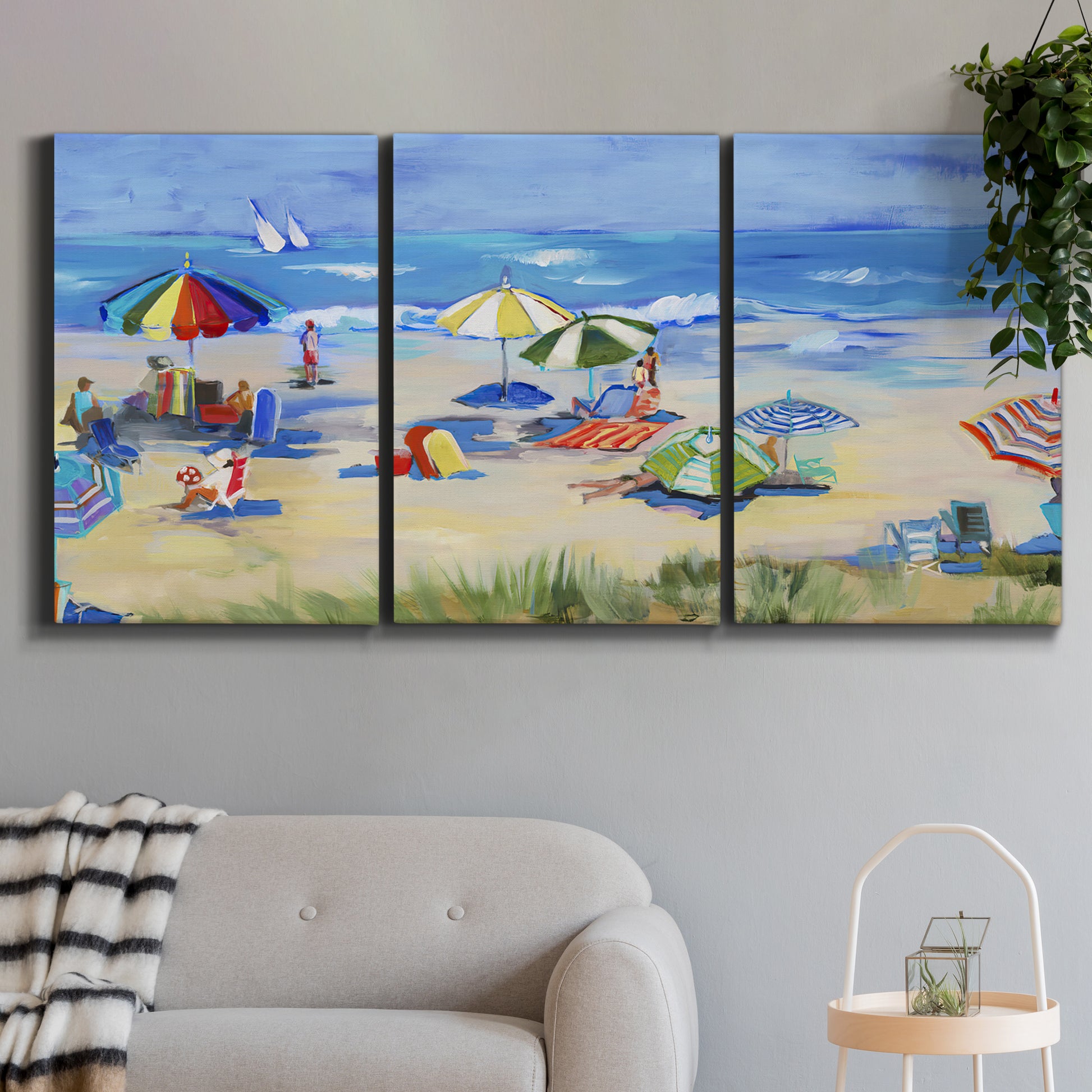 Three-panel canvas wall art featuring sunny coastal beachscape with horizon, displayed in a modern living room above a sofa.