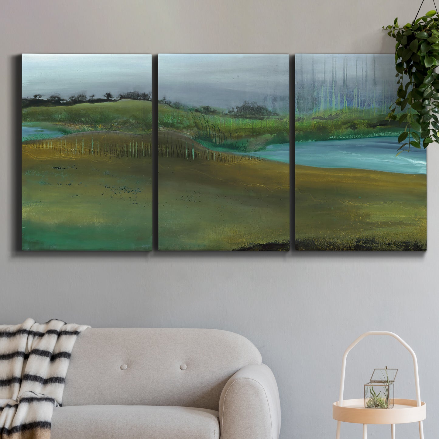 Three-panel canvas wall art featuring quiet contemplative landscape scene, displayed in a modern living room above a sofa.