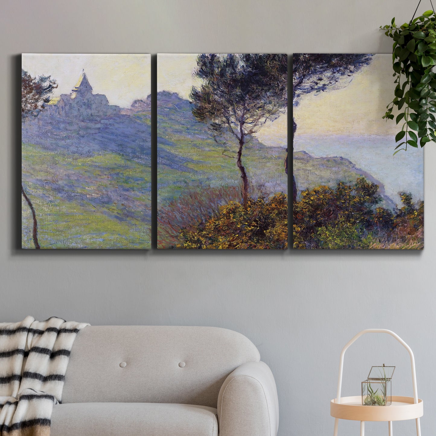 Three-panel canvas wall art featuring village church at sunset, displayed in a modern living room above a sofa.