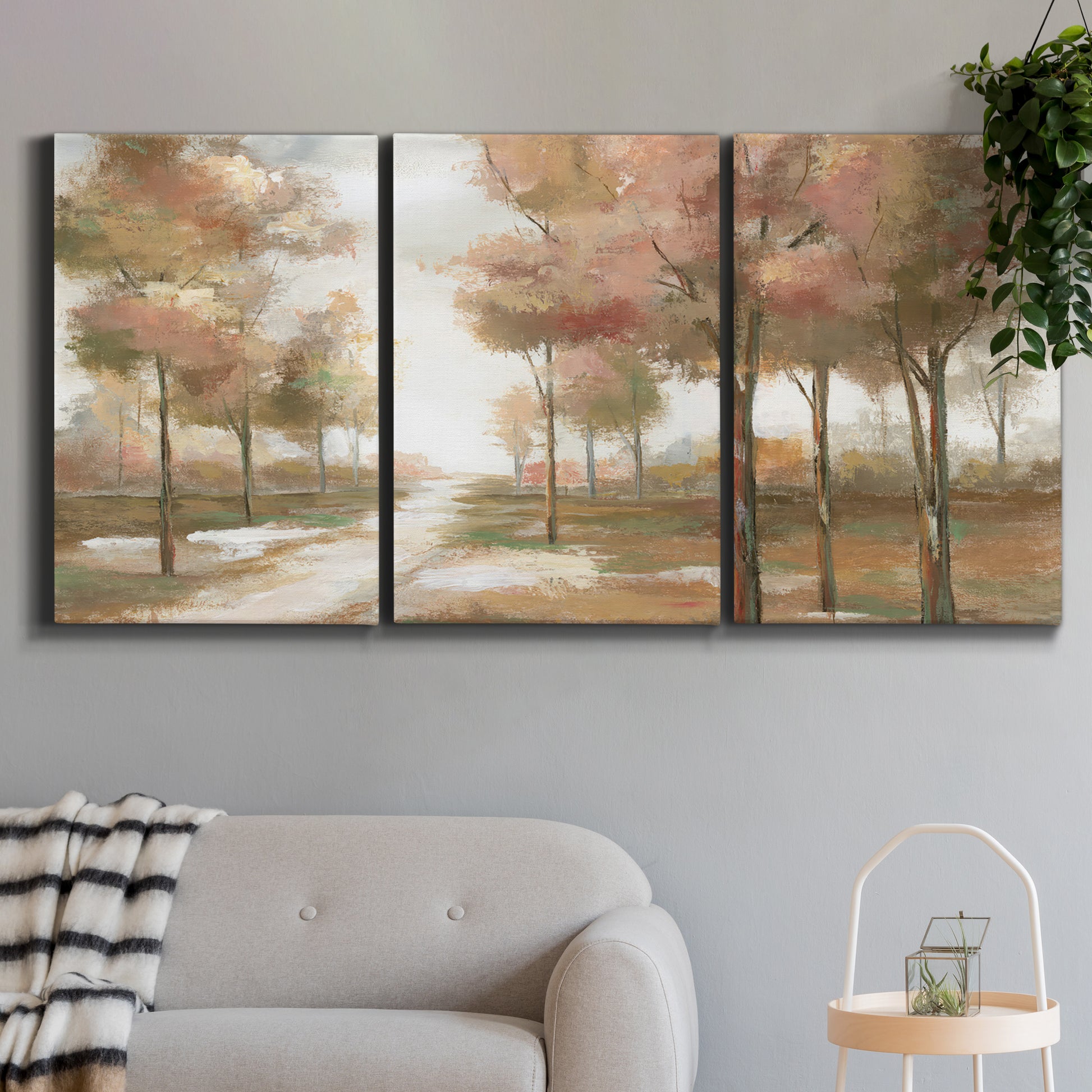 Three-panel canvas wall art featuring soft pastel park landscape scene, displayed in a modern living room above a sofa.