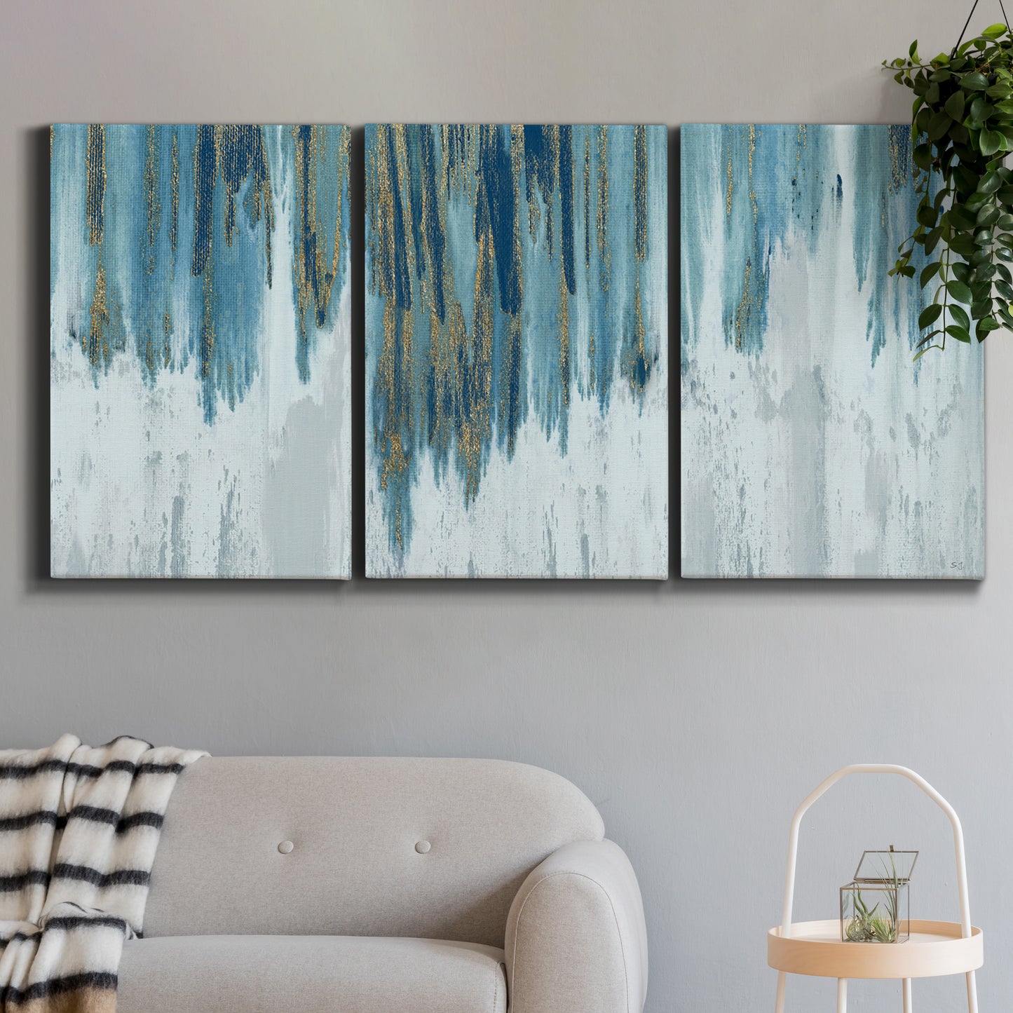 Three-panel canvas wall art featuring wide pastoral valley landscape, displayed in a modern living room above a sofa.
