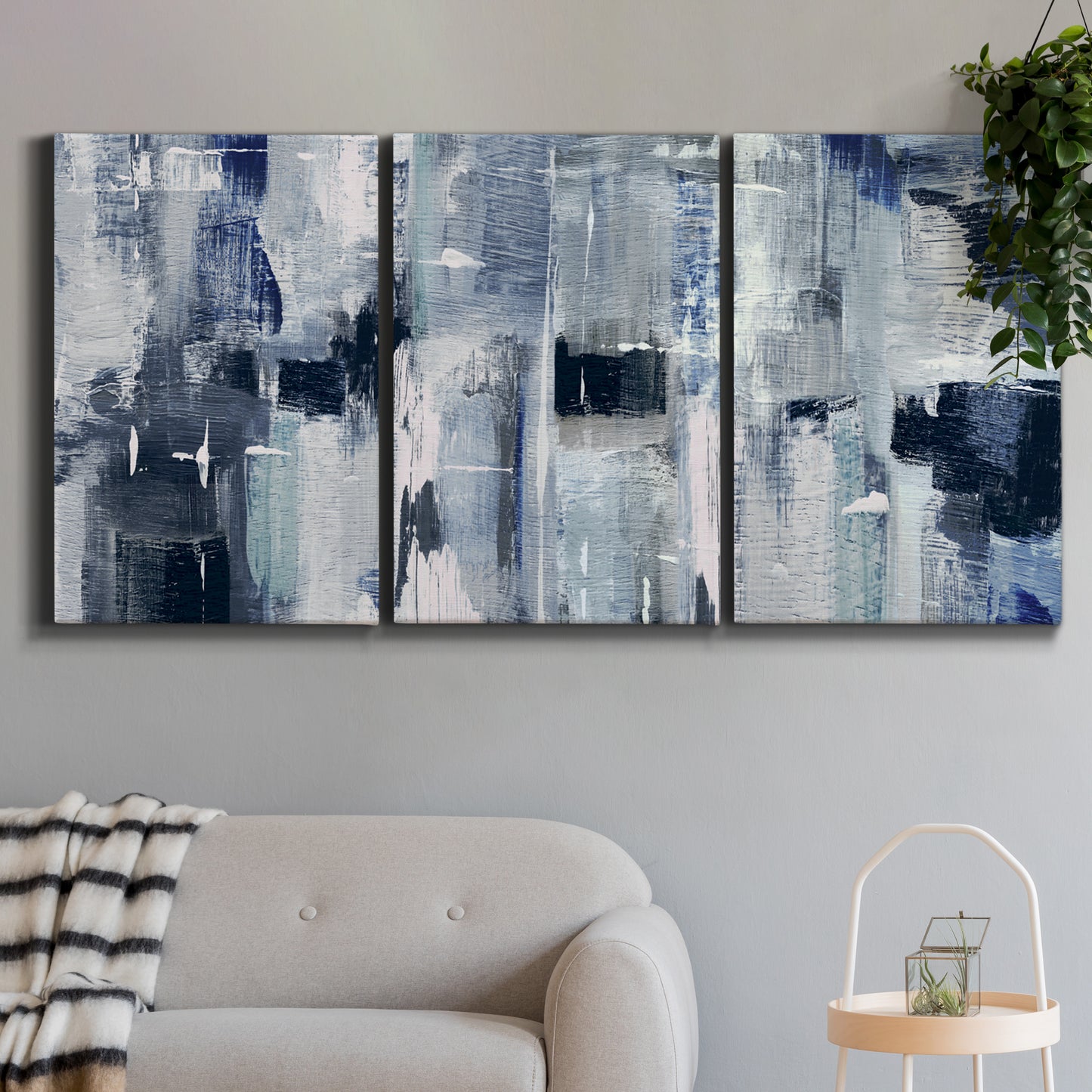 Three-panel canvas wall art featuring soft abstract mountain color fields, displayed in a modern living room above a sofa.