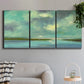 Three-panel canvas wall art featuring still lagoon water beneath open sky, displayed in a modern living room above a sofa.