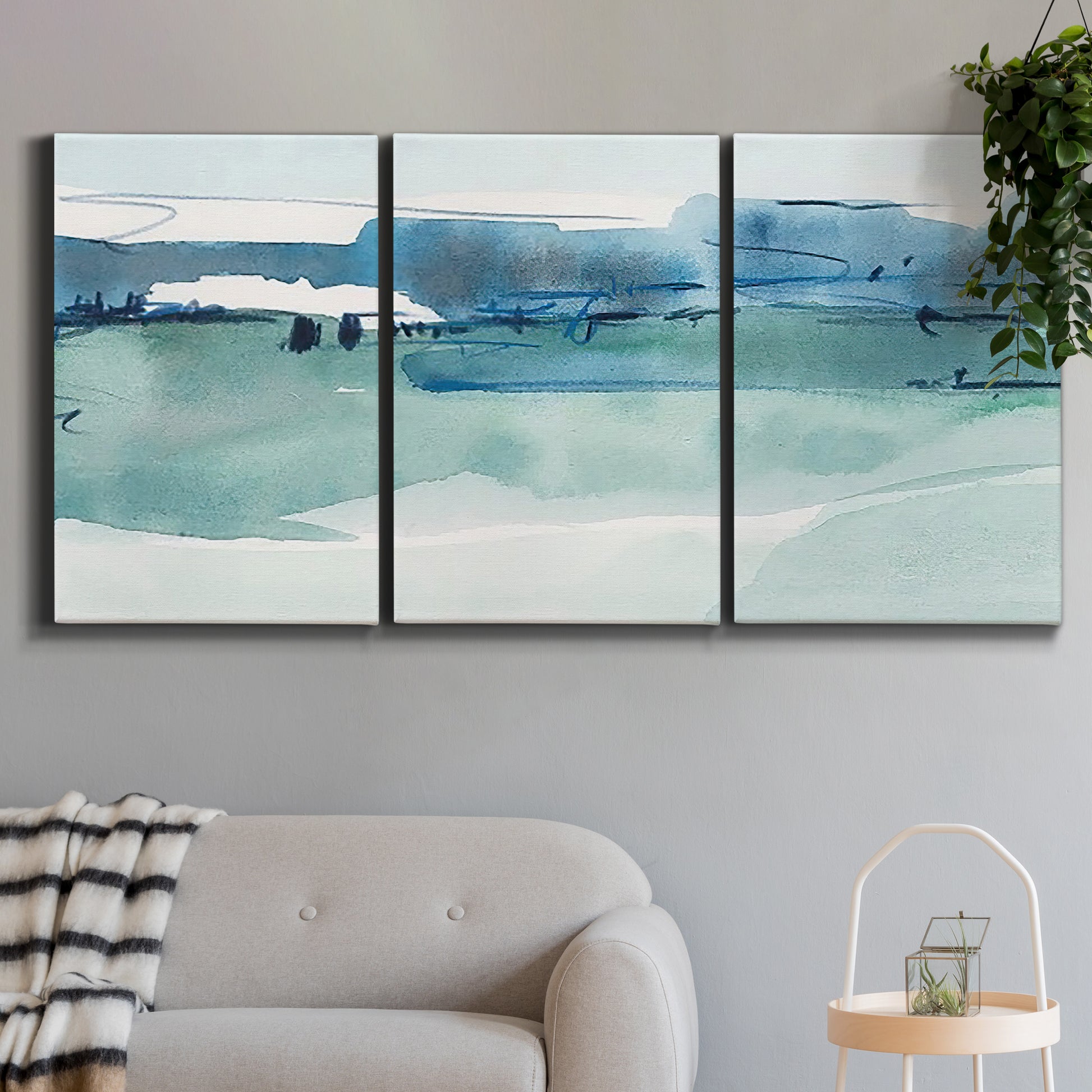 Three-panel canvas wall art featuring minimalist ultramarine abstract vista, displayed in a modern living room above a sofa.