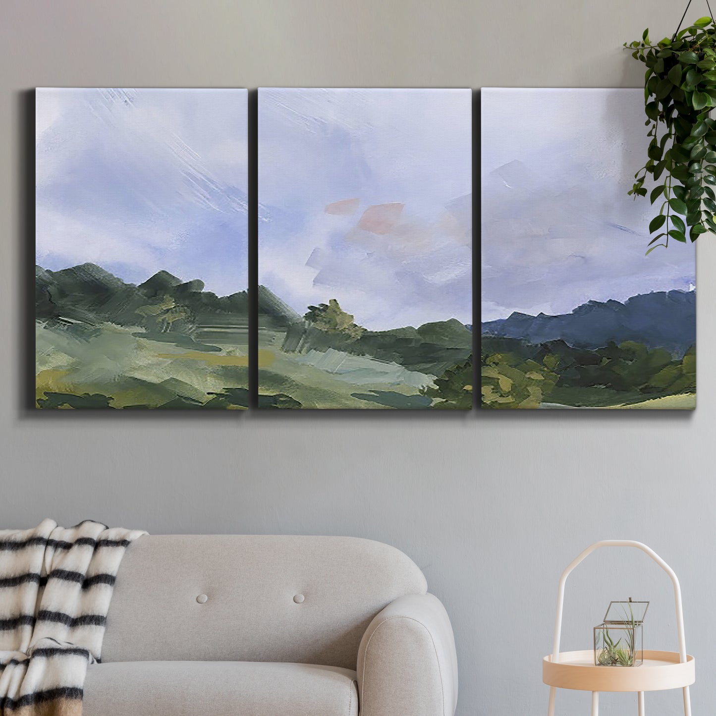 Three-panel canvas wall art featuring wide open pastoral horizon landscape, displayed in a modern living room above a sofa.