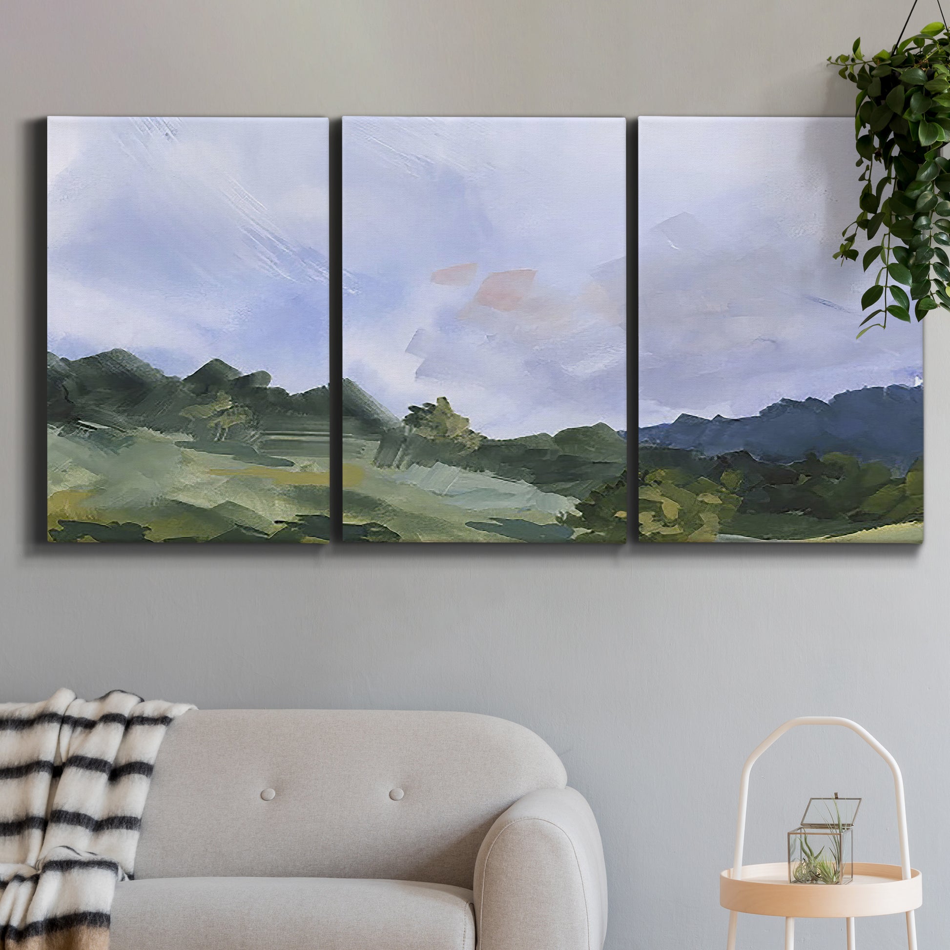 Three-panel canvas wall art featuring wide open pastoral horizon landscape, displayed in a modern living room above a sofa.