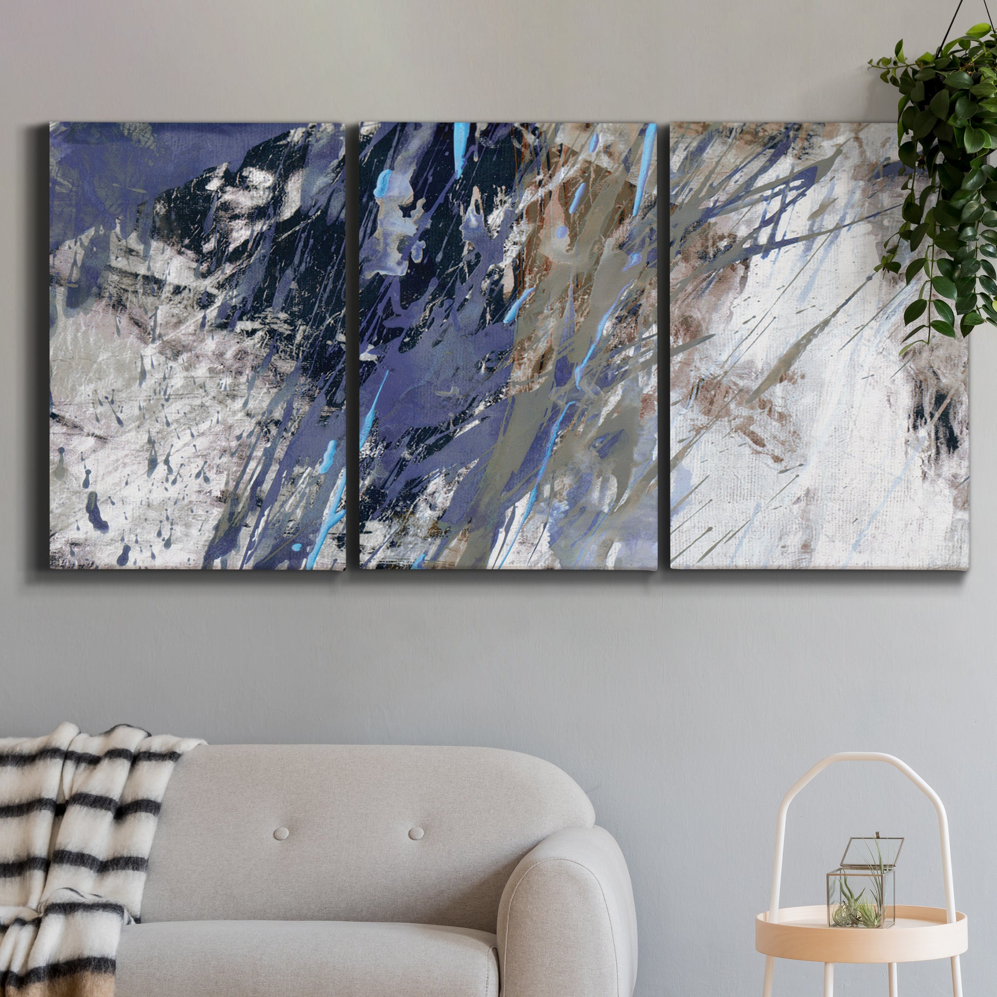Three-panel canvas wall art featuring textured blue abstract composition, displayed in a modern living room above a sofa.