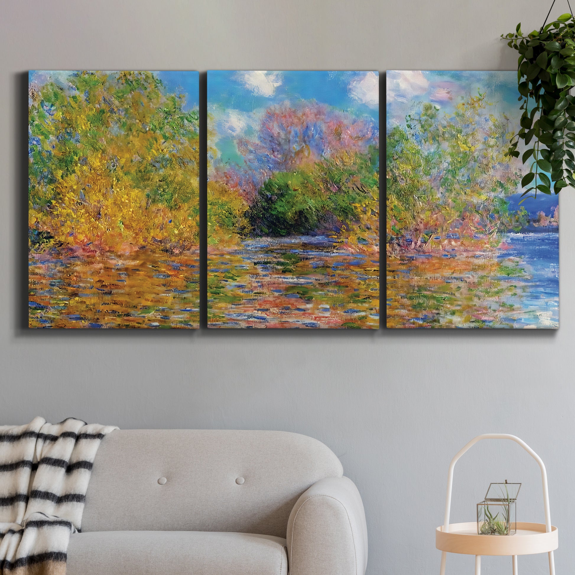 Three-panel canvas wall art featuring wide river landscape, displayed in a modern living room above a sofa.