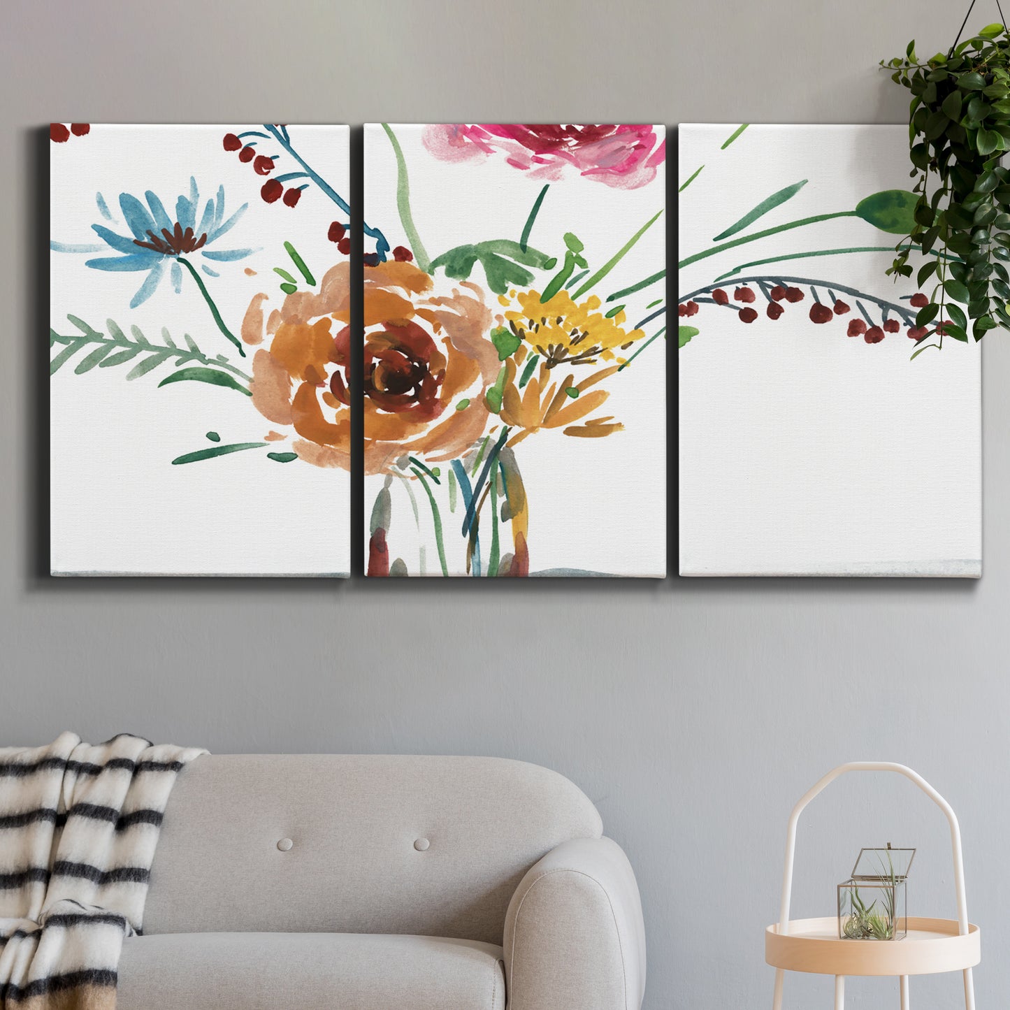 Three-panel canvas wall art featuring vibrant floral bouquet, displayed in a modern living room above a sofa.