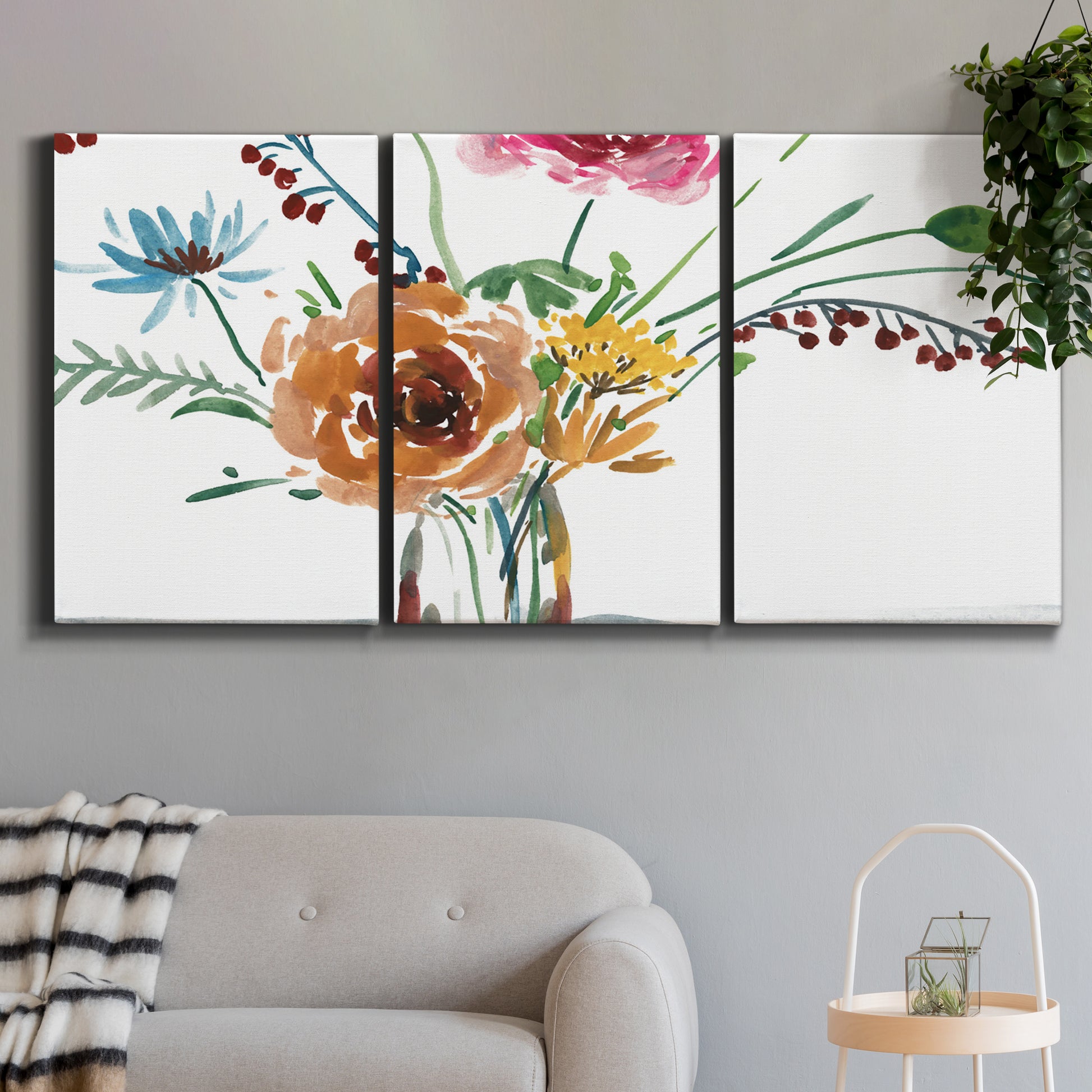Three-panel canvas wall art featuring vibrant floral bouquet, displayed in a modern living room above a sofa.