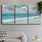 Three-panel canvas wall art featuring tropical beach scene with turquoise water, displayed in a modern living room above a sofa.