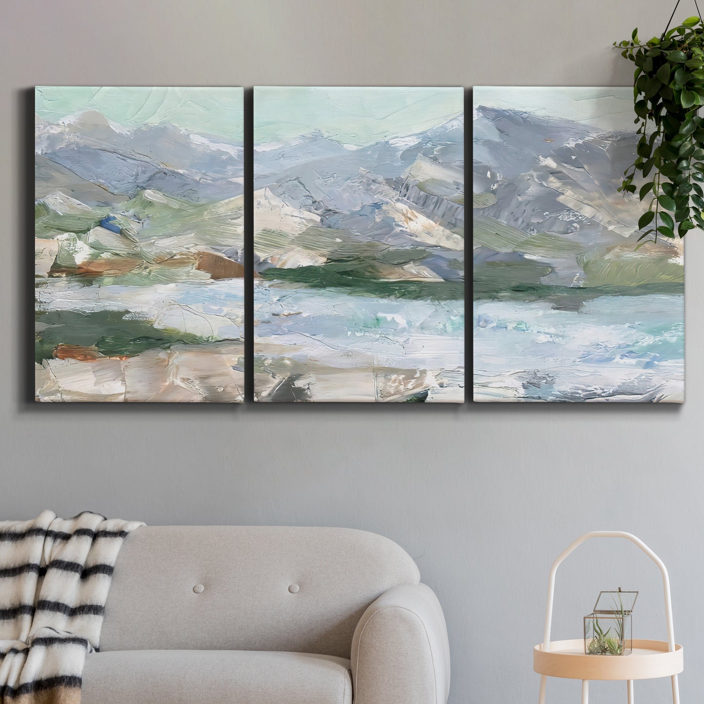Three-panel canvas wall art featuring pastel mountain landscape view, displayed in a modern living room above a sofa.