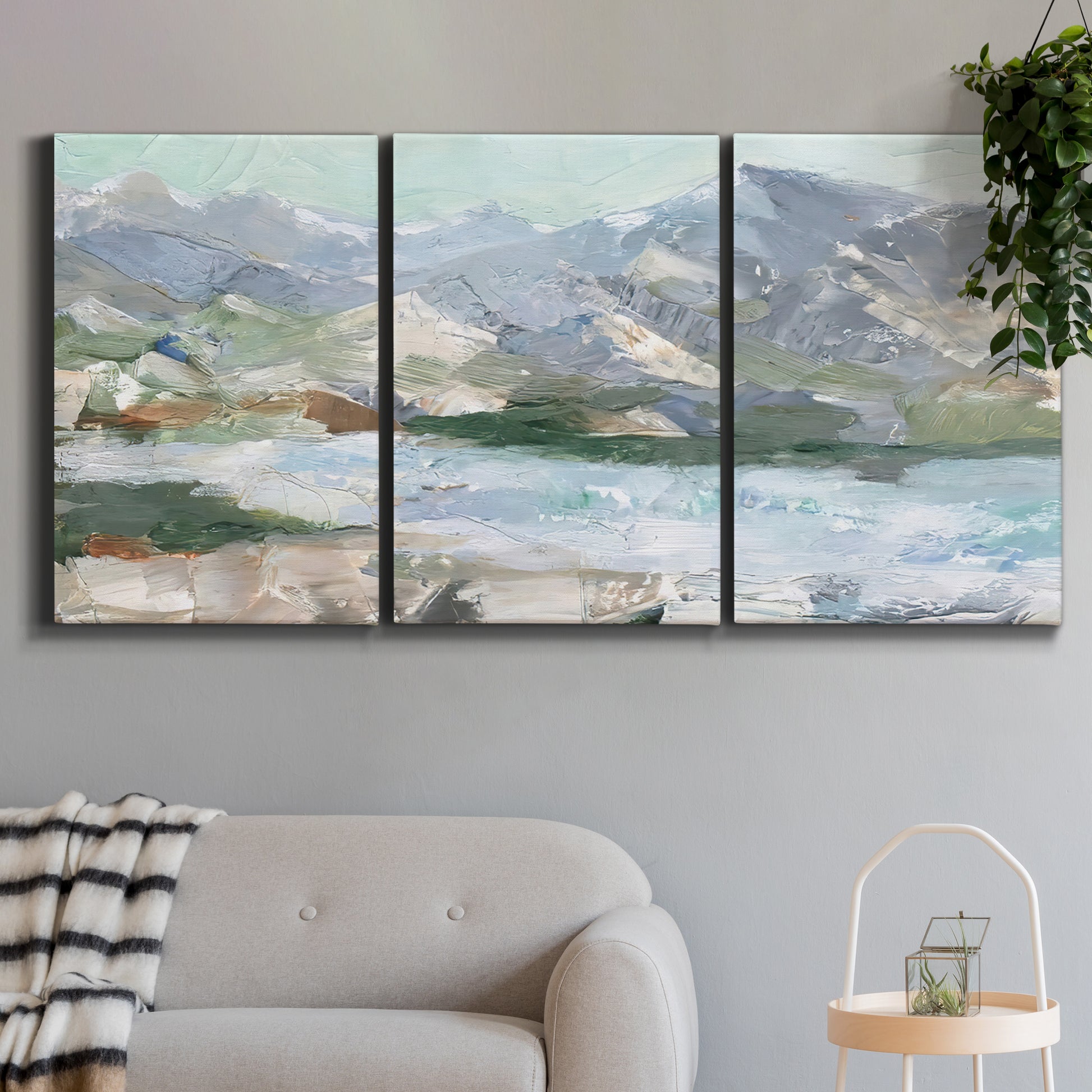 Three-panel canvas wall art featuring pastel mountain landscape view, displayed in a modern living room above a sofa.