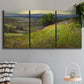 Three-panel canvas wall art featuring winding path through rolling hills, displayed in a modern living room above a sofa.