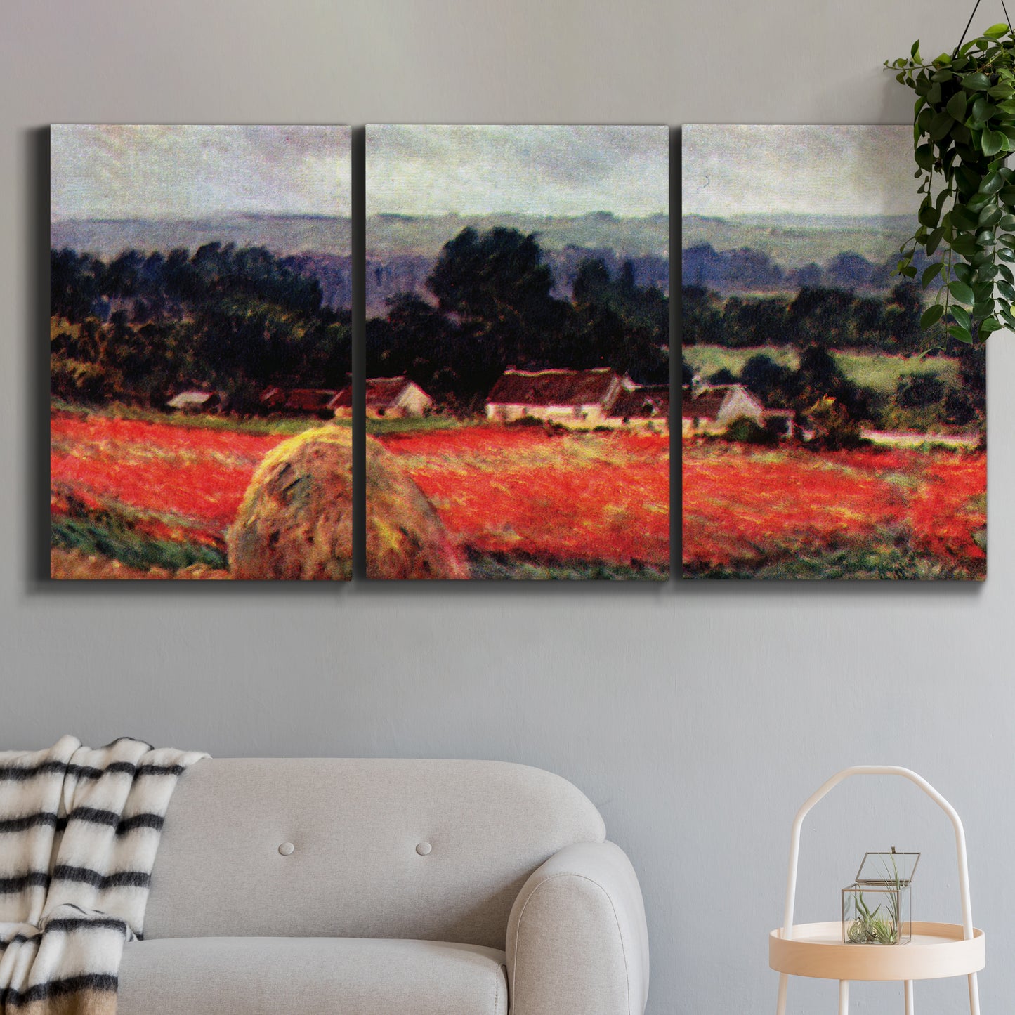 Three-panel canvas wall art featuring red poppy field near barn, displayed in a modern living room above a sofa.