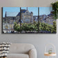 Three-panel canvas wall art featuring gothic church within city setting, displayed in a modern living room above a sofa.
