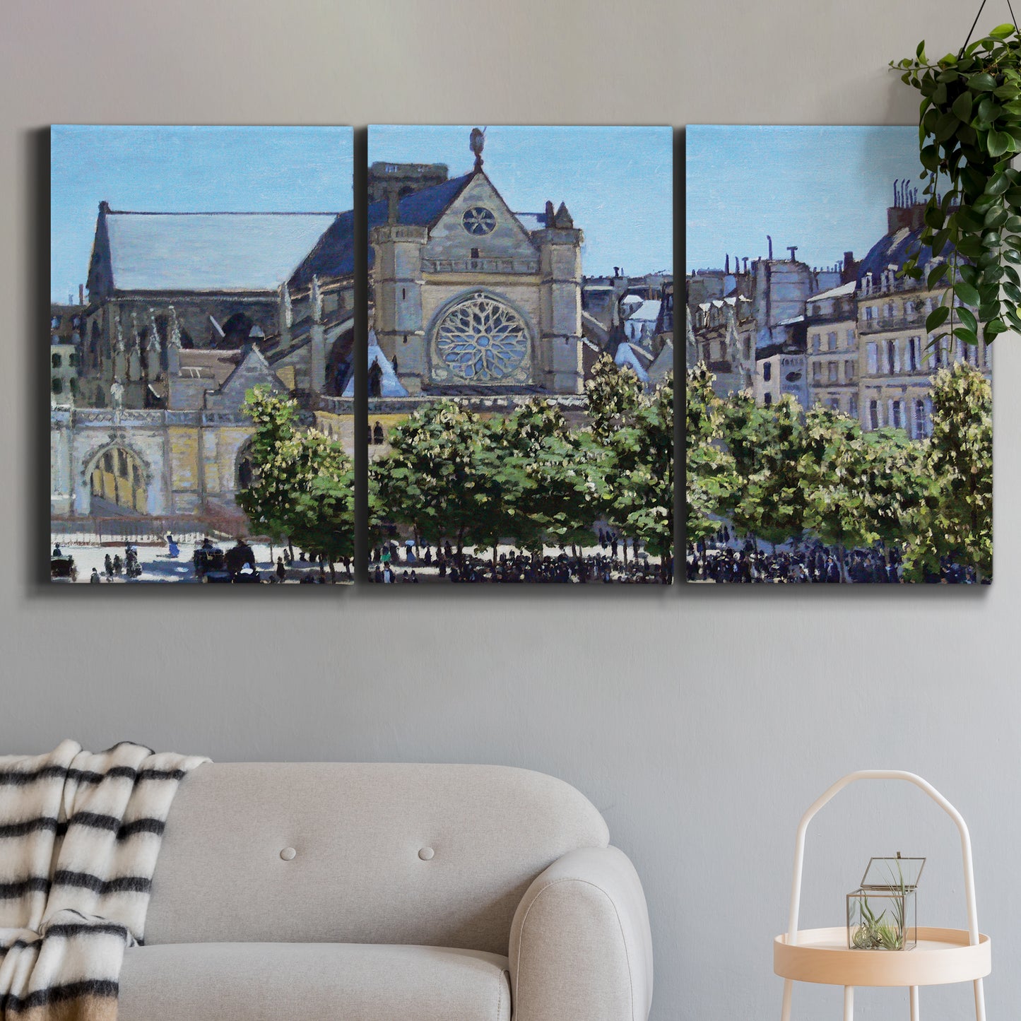 Three-panel canvas wall art featuring gothic church within city setting, displayed in a modern living room above a sofa.