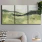 Three-panel canvas wall art featuring rolling hillside countryside landscape, displayed in a modern living room above a sofa.