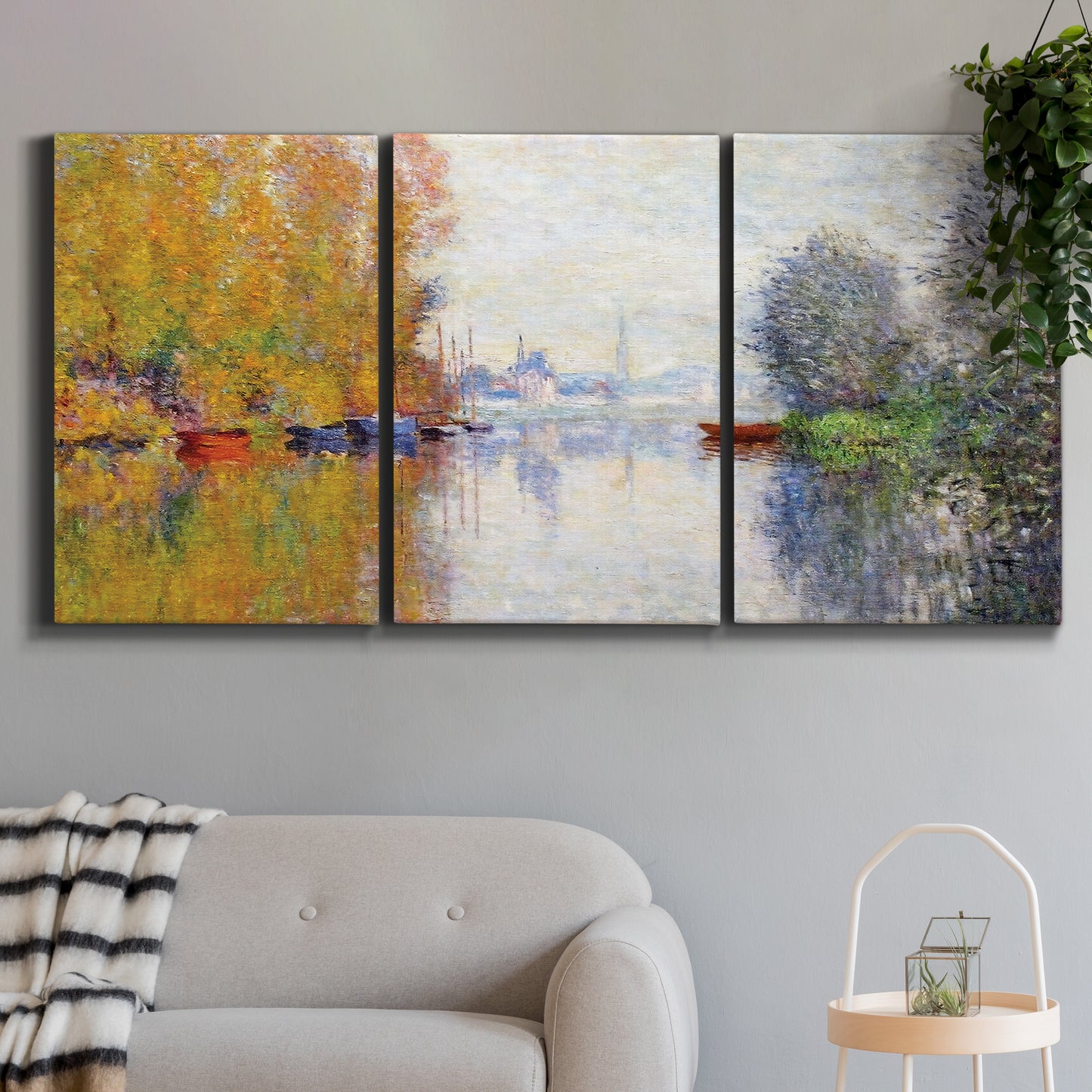 Three-panel canvas wall art featuring golden autumn light over riverside, displayed in a modern living room above a sofa.